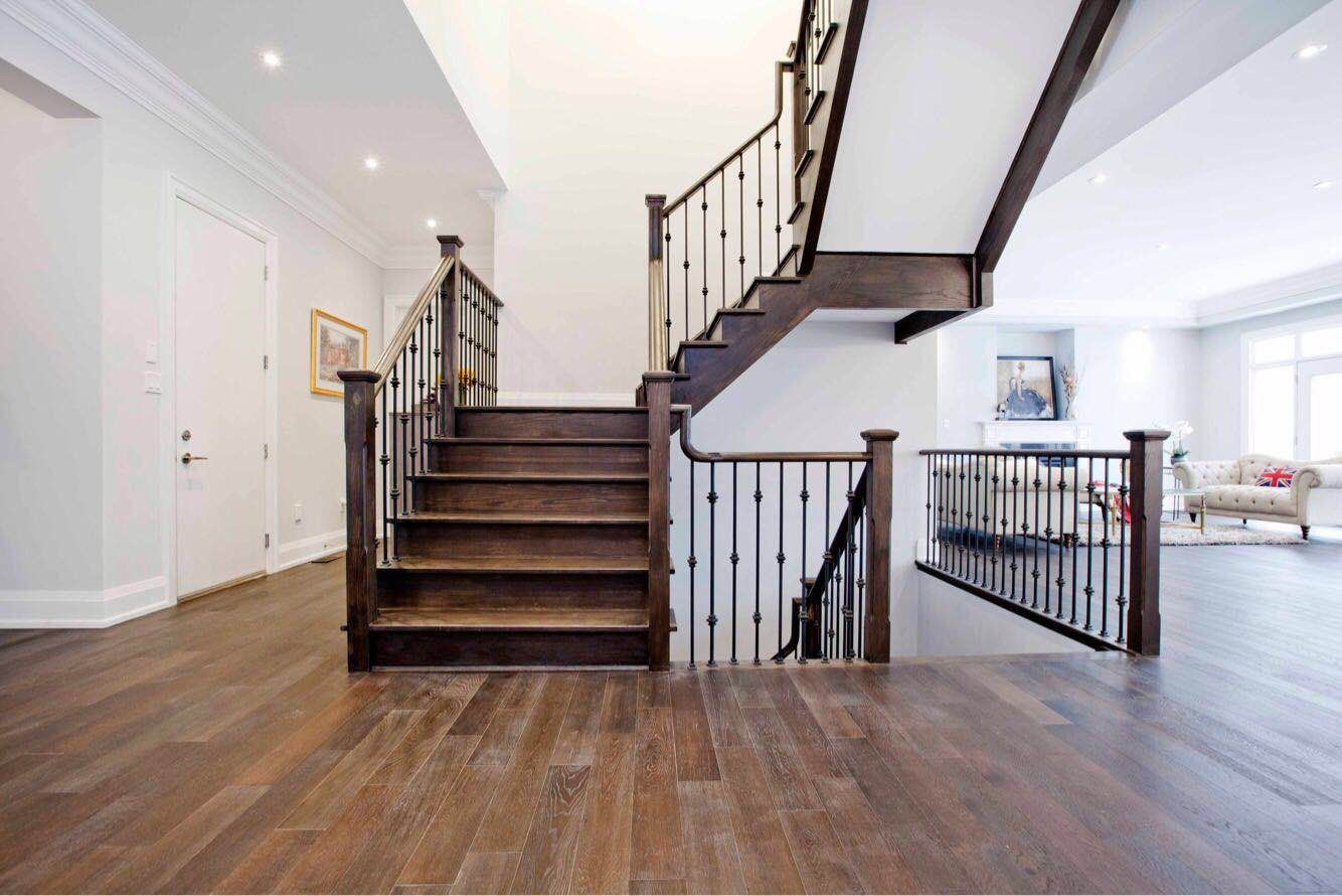 Custom hardwood staircase with decorative metal railings completed as part of a Toronto design build custom build project. The staircase features detailed craftsmanship, durable hardwood steps, and an open railing design that enhances the visual flow between levels. This whole house renovation Toronto project highlights the architectural details and high-end finishes commonly found in luxury custom homes across Toronto.