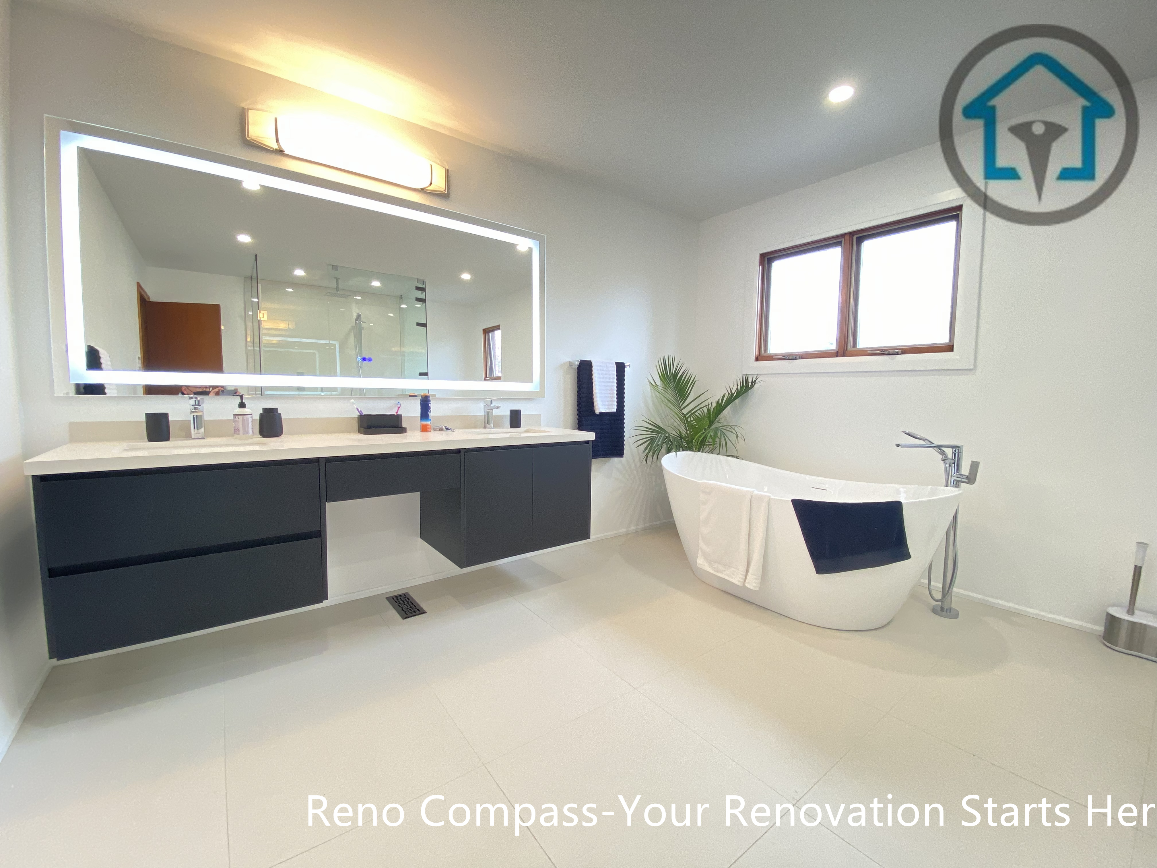 Contemporary bathroom renovation in Brampton featuring a floating double vanity with matte black cabinetry, integrated sinks, and a backlit LED mirror. The wall-mounted design enhances visual openness while improving floor drainage and ease of cleaning. Completed by an experienced Toronto renovation company, this vanity upgrade combines modern aesthetics, functional storage, and long-term everyday usability.