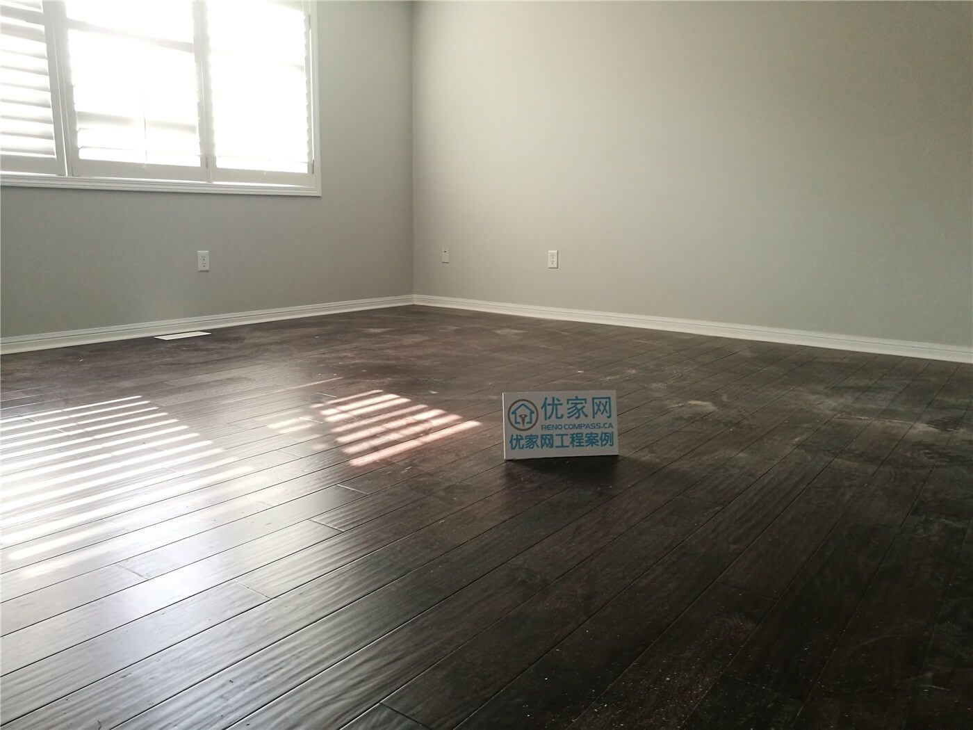 This Scarborough flooring replacement project features newly installed dark hardwood flooring that enhances the room’s depth and modern appeal. The rich wood tone contrasts beautifully with the light grey walls and white baseboards, creating a clean and contemporary atmosphere. Installed by a professional Toronto Renovation Company, the flooring was precisely aligned for a seamless finish and long-term durability.