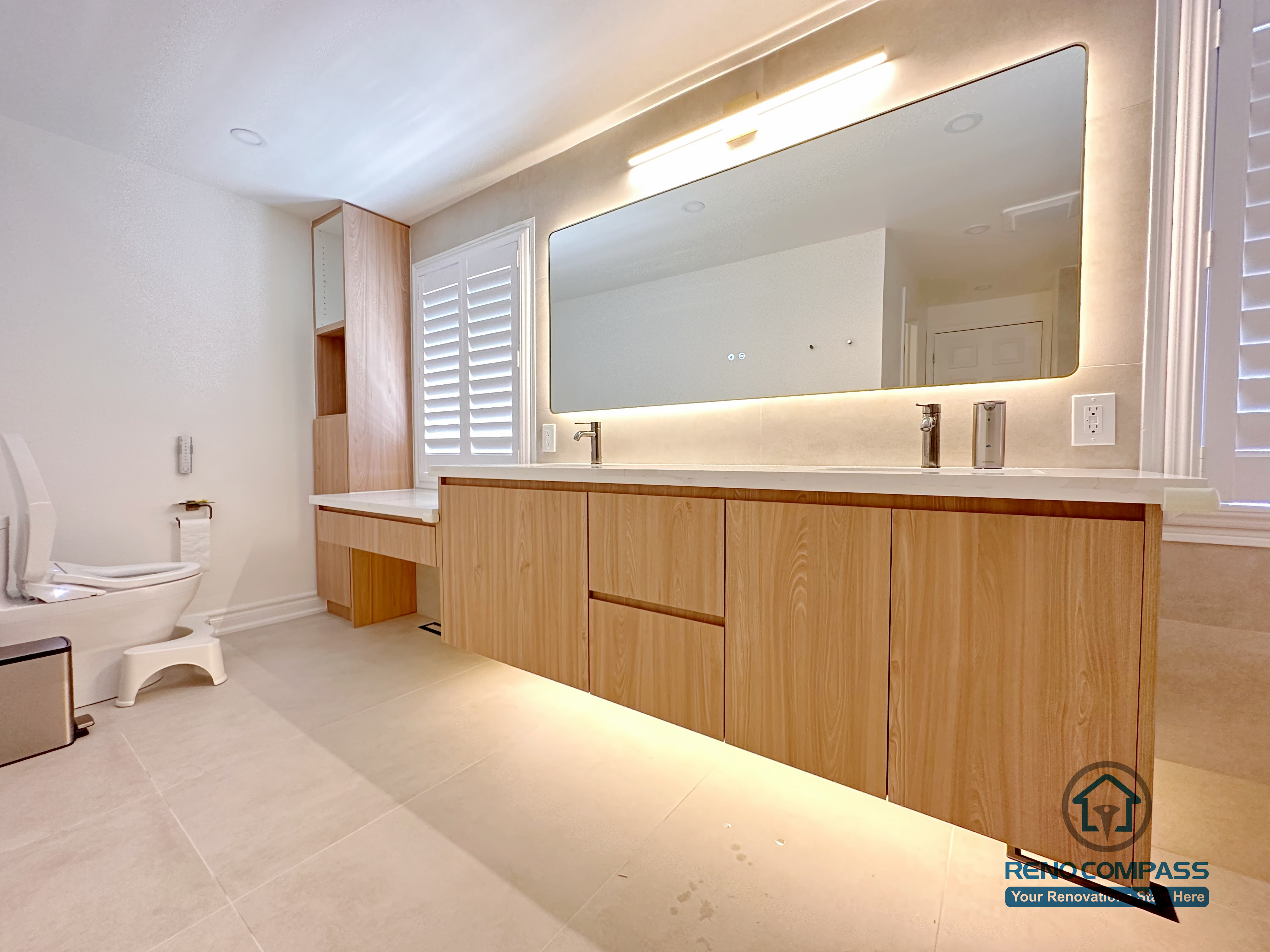 This Markham accessible bathroom renovation features a custom wood-tone vanity with ample floor clearance, integrated lighting, and easy reach access, paired with a thoughtfully positioned toilet area to support safe and comfortable movement. Wide-format tile flooring and unobstructed circulation improve accessibility without compromising design quality. Designed and built by a professional Toronto renovation company, Reno Compass Inc., the space prioritizes safety, usability, and long-term comfort.