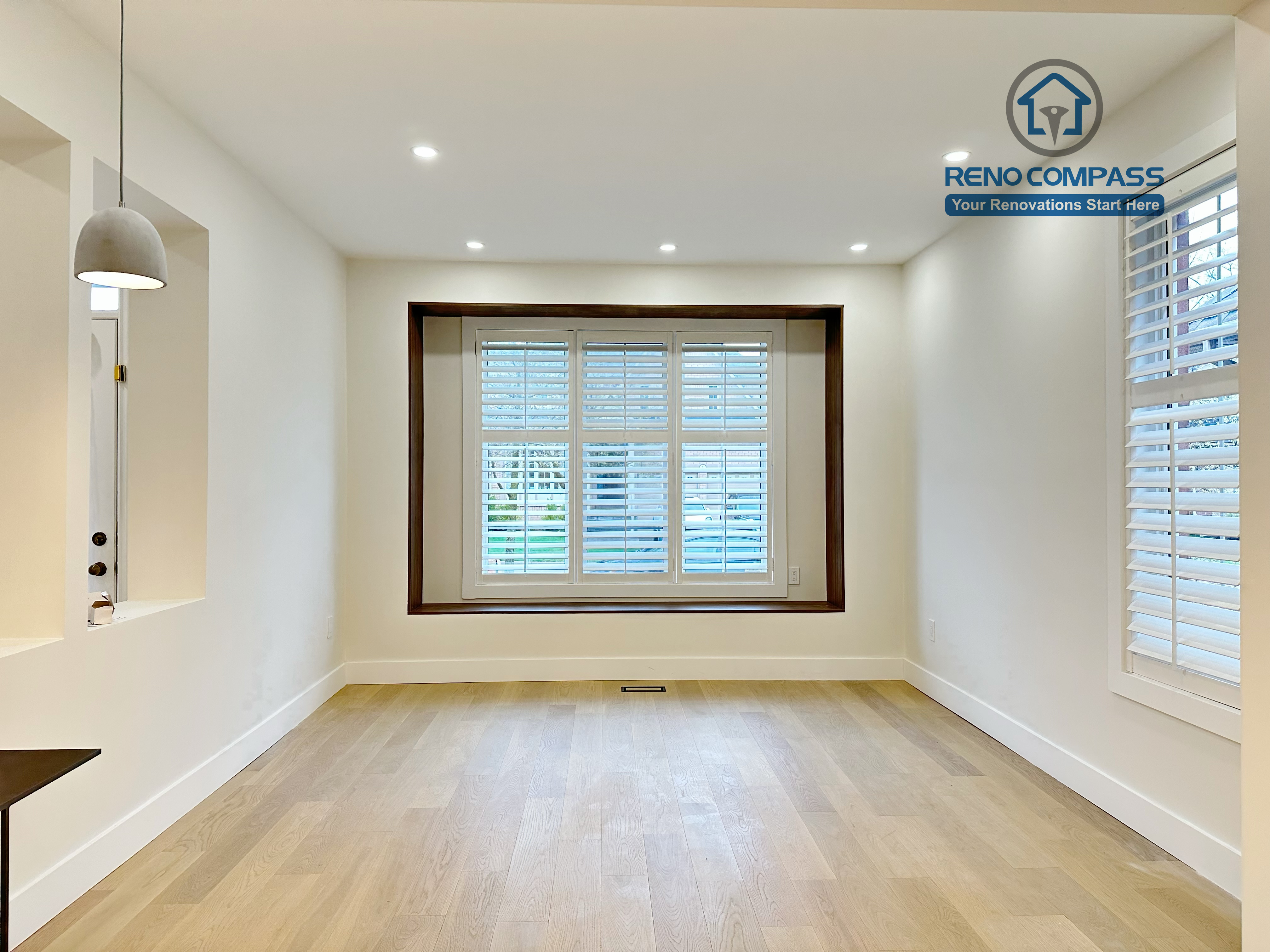 Bright interior room in a Richmond Hill home showcasing newly installed light-tone hardwood flooring, recessed ceiling lights, and custom window trim, enhancing natural light and a clean, modern finish.
