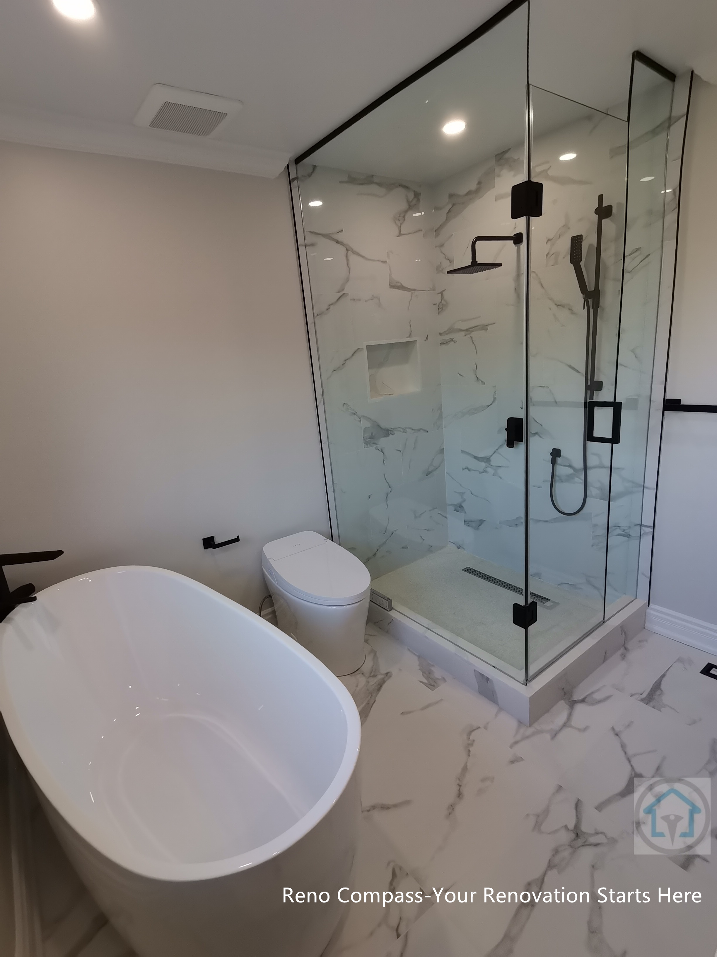 This Thornhill bathroom renovation features a glass-enclosed shower with marble-style wall tiles, modern black fixtures, and a built-in niche for storage. The clean layout integrates the shower area seamlessly with the rest of the bathroom, creating a bright, functional, and well-balanced space for everyday use.