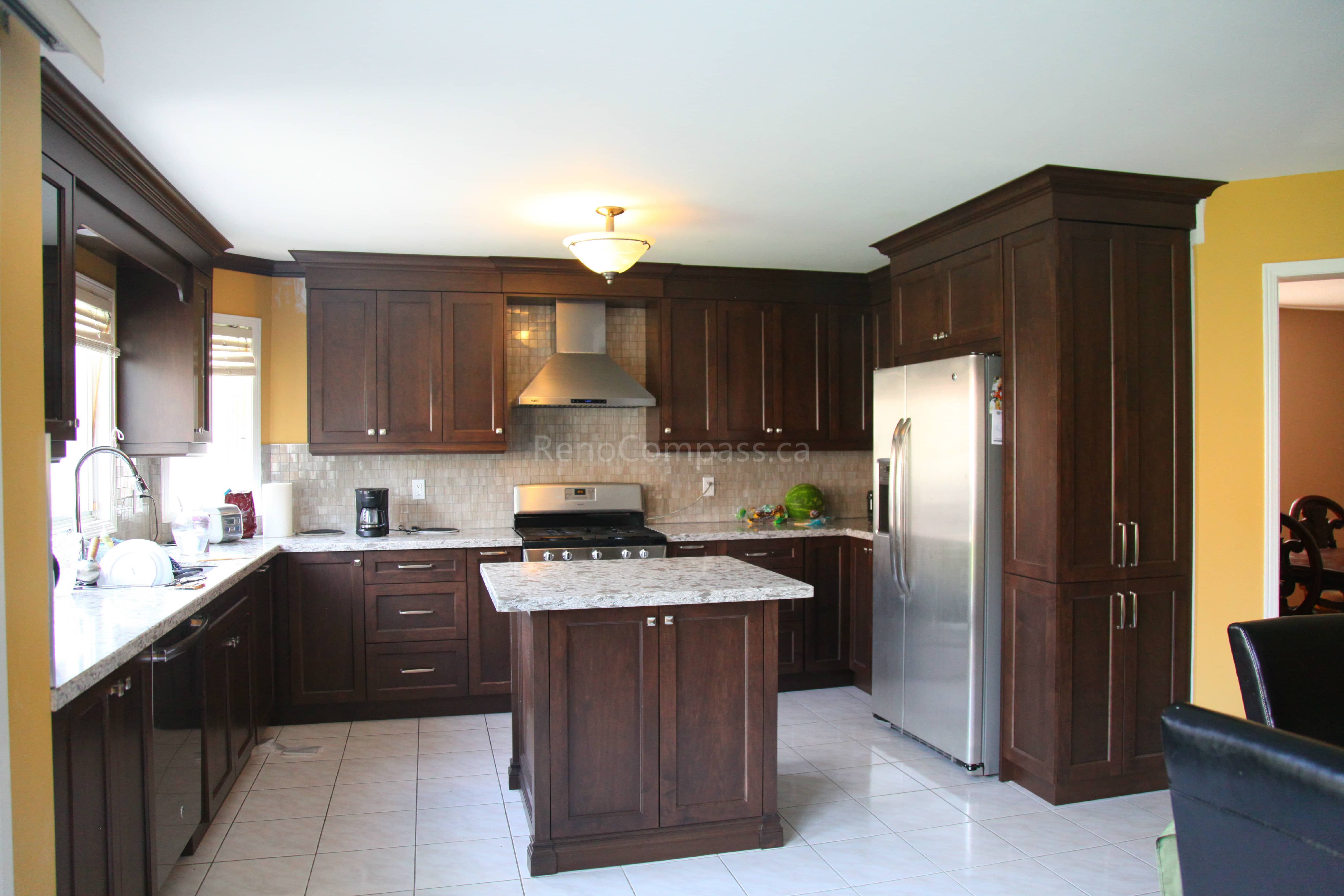 This Markham kitchen renovation features rich dark wood cabinetry, a custom quartz island, and modern stainless steel appliances, creating a warm and functional cooking space. Designed and completed by a professional Toronto renovation company, the layout enhances storage, workflow, and overall visual appeal while maintaining a timeless and elegant kitchen design.