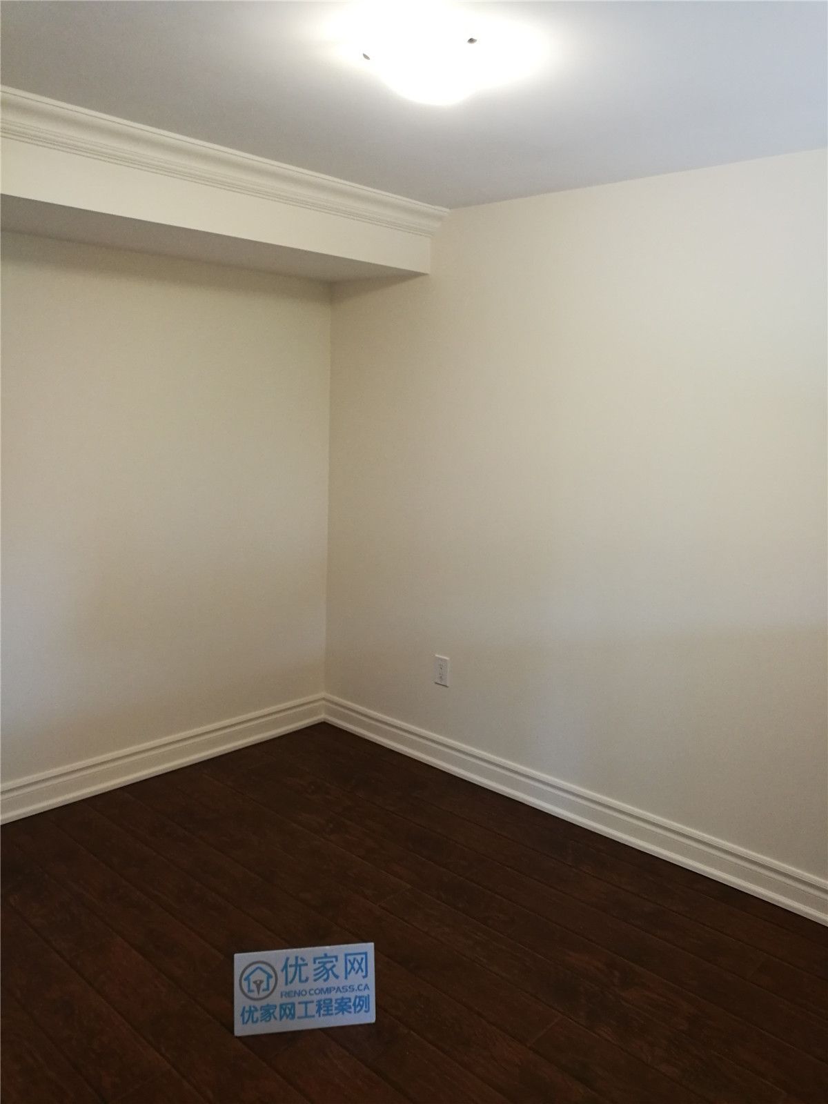 Finished interior room as part of a Toronto interior renovation project, featuring dark wood flooring, smooth wall finishes, crown molding, and clean baseboard trim. The space offers a simple, versatile layout suitable for a bedroom, office, or multi-purpose living area.