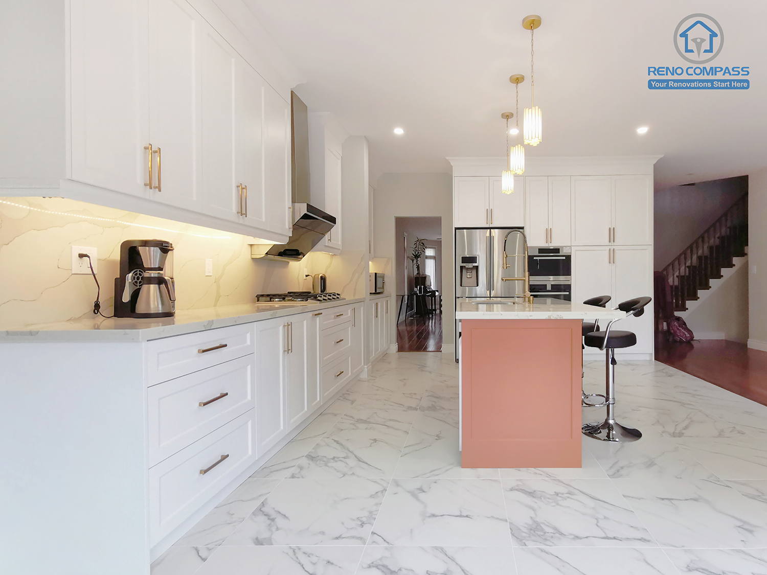 This Markham interior renovation presents a full-scale perspective of a custom-designed kitchen that emphasizes clarity, proportion, and daily functionality. The layout features continuous white shaker cabinetry, large-format marble-look porcelain flooring, and a central island that anchors the space visually and functionally. Integrated appliances and concealed storage solutions maintain a clean, uninterrupted elevation, while warm accent tones on the island introduce subtle contrast without breaking the overall balance. Layered lighting enhances depth and usability across work zones. Completed by Reno Compass, this kitchen renovation reflects a carefully coordinated interior design approach tailored to modern Markham homes seeking timeless aesthetics and long-term livability.