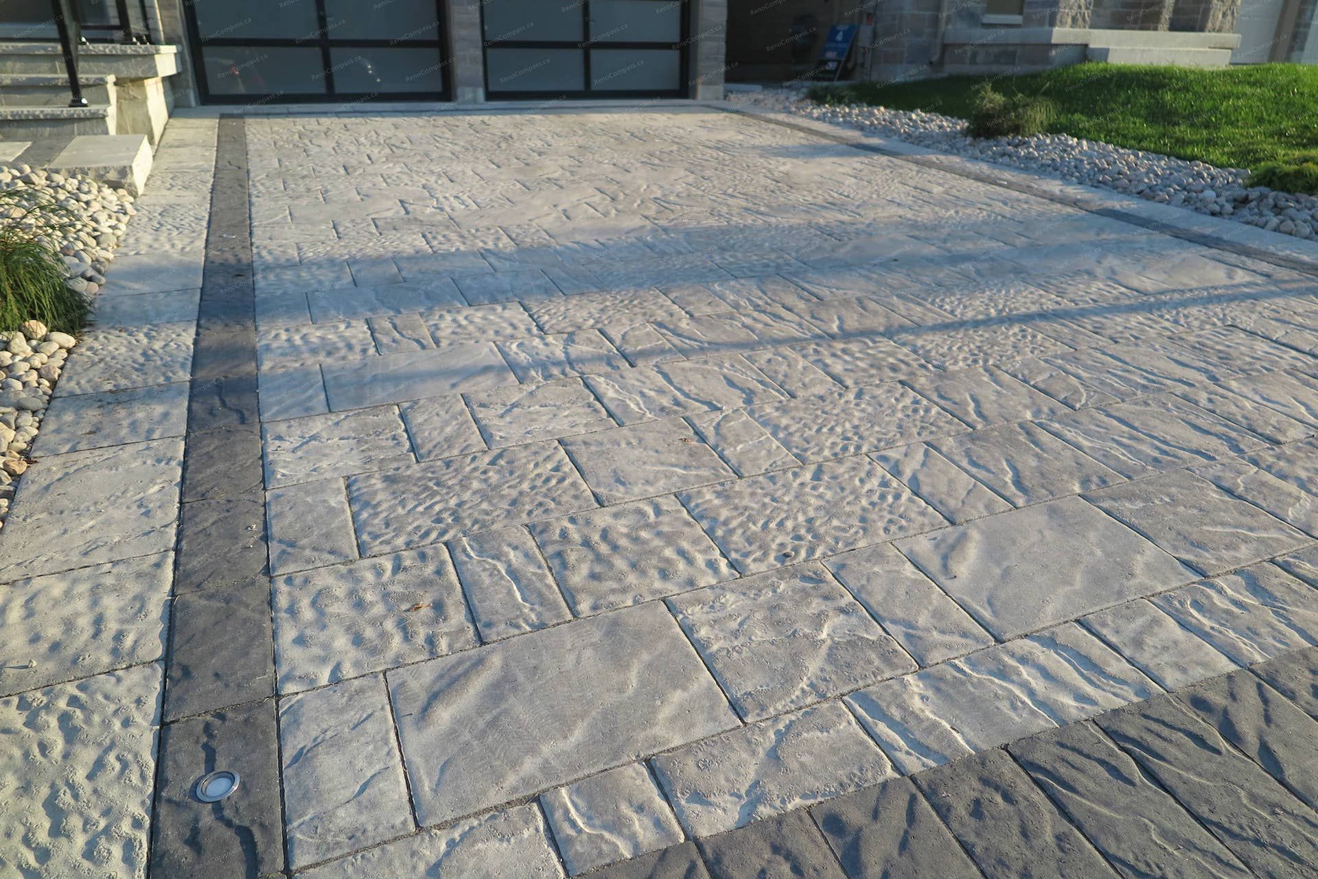 Stamped concrete driveway installation for a detached home in Vaughan, designed with natural stone texture patterns and decorative border accents. This front yard renovation combines durability and elegant curb appeal, creating a modern and low-maintenance driveway that complements the home’s contemporary exterior and landscaping design.