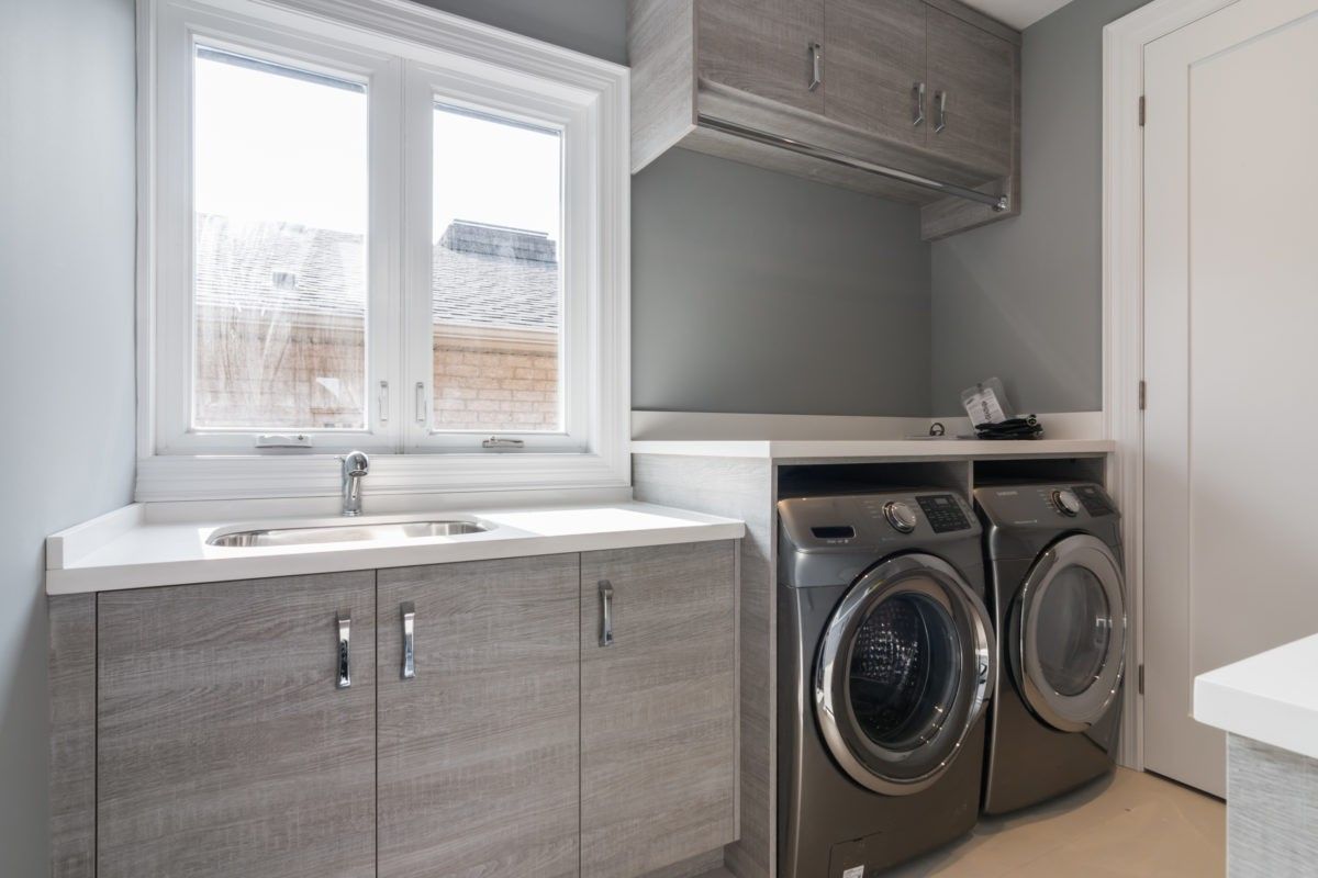 This custom-designed laundry room is part of a 4,500 sq ft luxury interior renovation in Toronto. Featuring built-in cabinetry, a quartz countertop with integrated utility sink, and a clean, functional layout, the space balances efficiency with contemporary aesthetics. The neutral color palette and organized storage system reflect thoughtful planning and premium workmanship. Completed by a professional Toronto Renovation Company, Reno Compass Inc., this project showcases practical luxury within a modern residential design.
