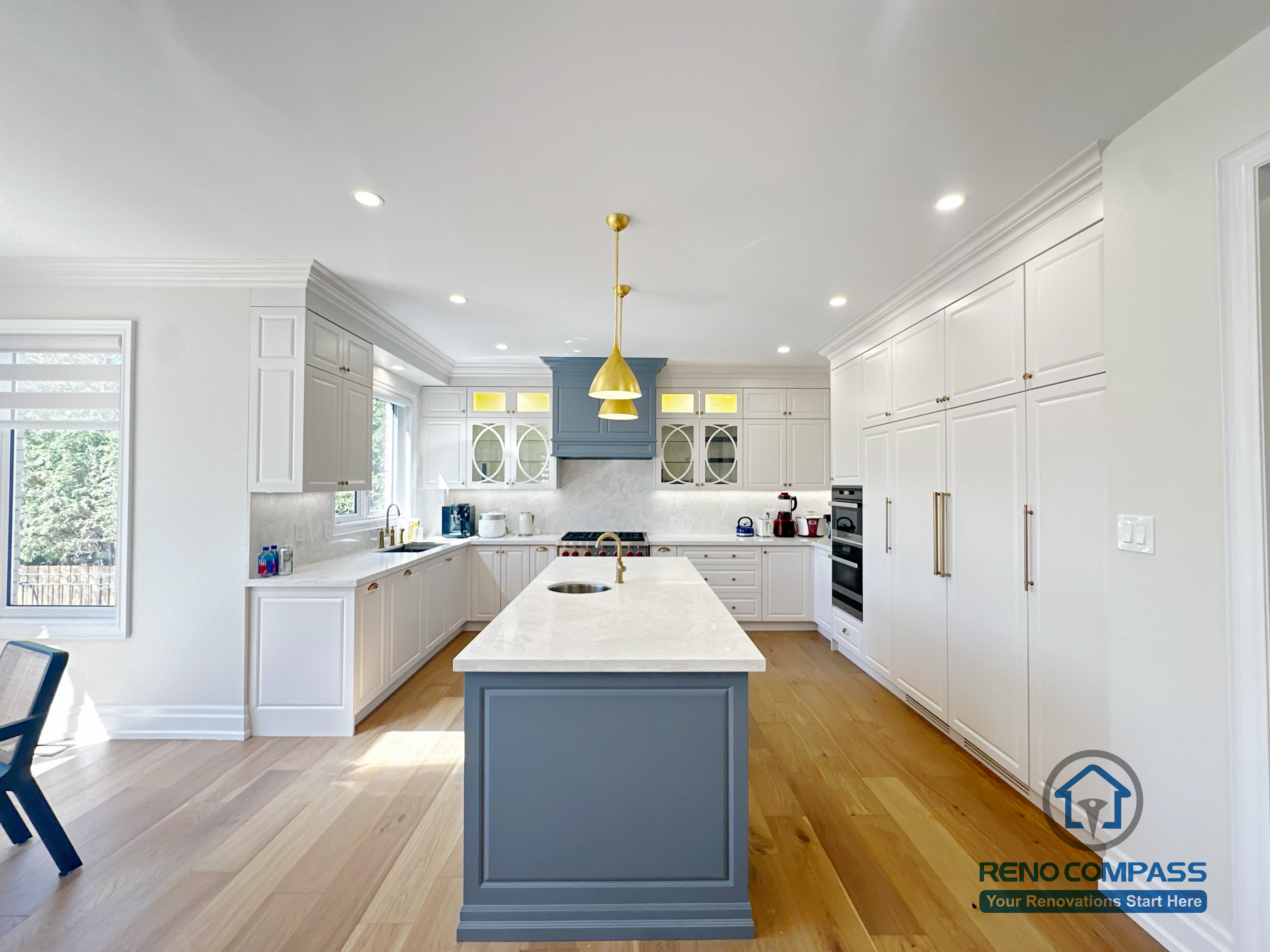 This North York kitchen renovation showcases a symmetrical layout centered around a custom island, with full-height cabinetry, balanced lighting, and clear circulation paths. The design emphasizes proportion, alignment, and everyday usability, creating a calm and organized kitchen environment completed by Reno Compass.