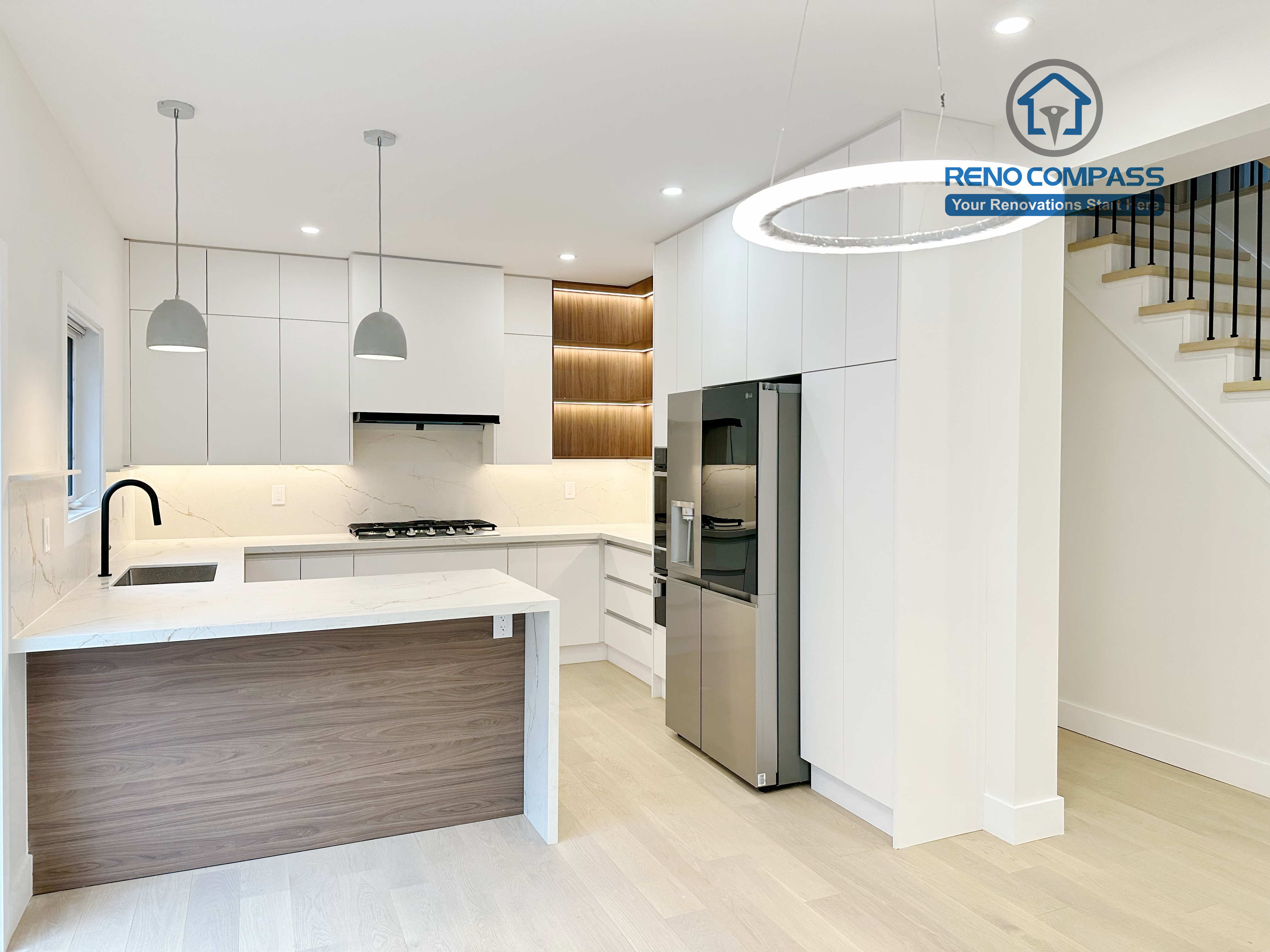 Modern kitchen renovation in Richmond Hill featuring white custom cabinets, quartz countertops, waterfall island, built-in appliances, and minimalist pendant lighting. This bright and functional kitchen remodel was completed by a professional Toronto Renovation Company, combining clean design with practical layout optimization.