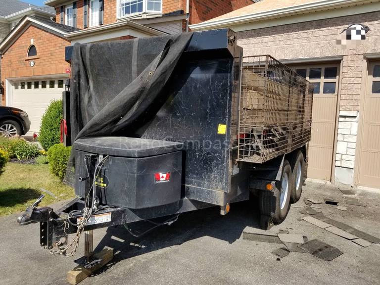 Roofing contractors removing damaged asphalt shingles during the Richmond Hill roofing replacement process to prepare the surface for underlayment installation.