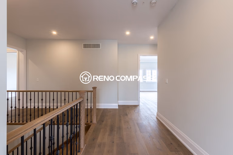 This image shows an upper floor area in a Newmarket home renovation project, featuring professionally installed engineered wood flooring and modern stair railings. The flooring provides a natural hardwood appearance with improved stability and durability. The project was completed by Reno Compass Inc., a Toronto renovation company specializing in flooring and interior renovations.