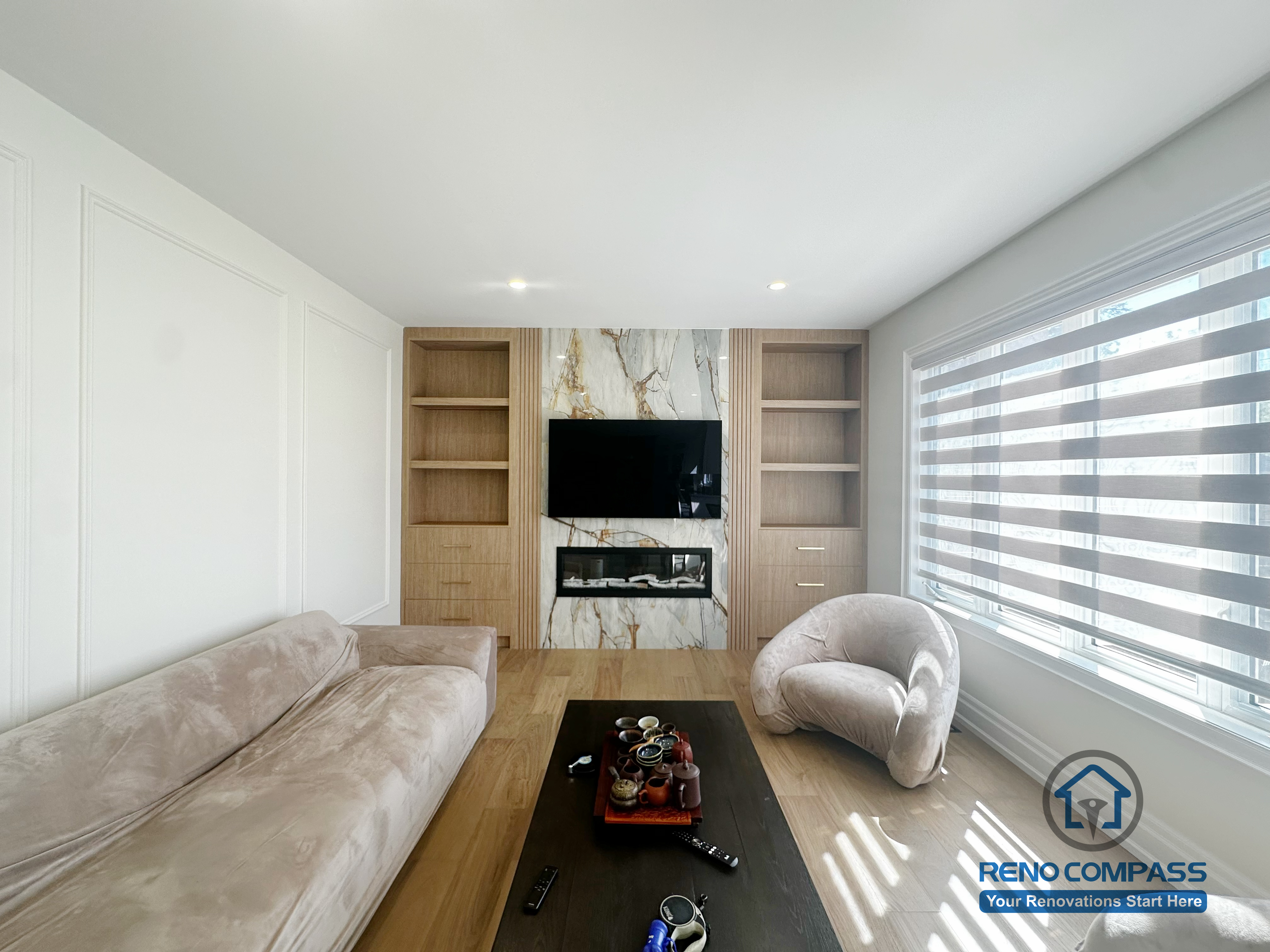 This image showcases a completed flooring renovation combined with a custom feature TV wall as part of a North York flooring and stair project. The space features wide-plank hardwood flooring that adds warmth and continuity throughout the living area. A custom-designed TV feature wall with built-in shelving and stone accent panels creates a strong focal point while maintaining a clean, modern aesthetic. This renovation demonstrates how coordinated flooring installation and feature wall design can enhance both functionality and visual impact in North York homes.