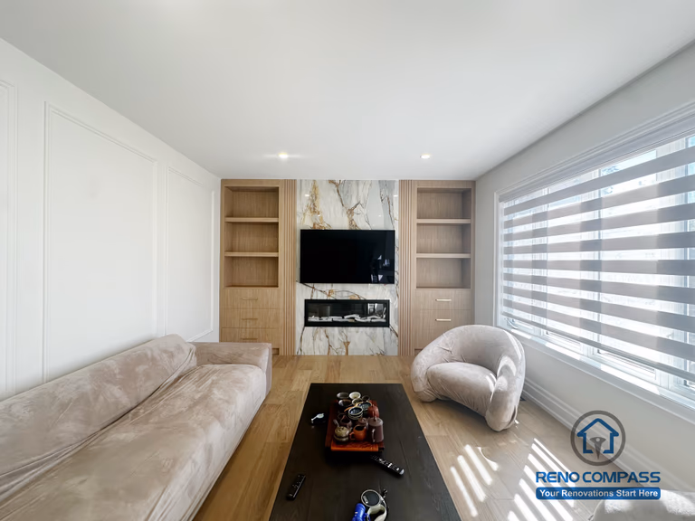 This image showcases a completed flooring renovation combined with a custom feature TV wall as part of a North York flooring and stair project. The space features wide-plank hardwood flooring that adds warmth and continuity throughout the living area. A custom-designed TV feature wall with built-in shelving and stone accent panels creates a strong focal point while maintaining a clean, modern aesthetic. This renovation demonstrates how coordinated flooring installation and feature wall design can enhance both functionality and visual impact in North York homes.
