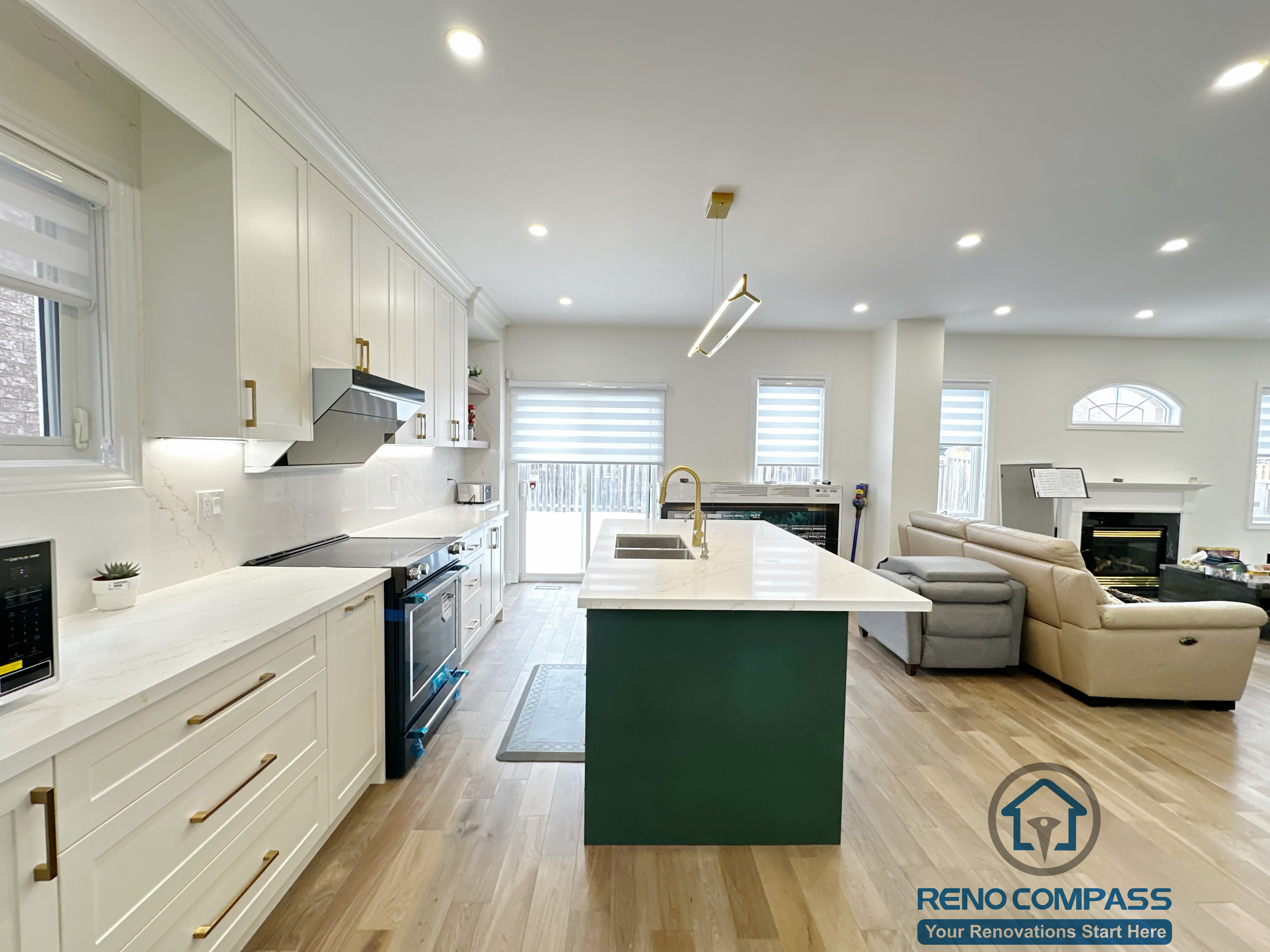 Open-concept interior renovation in Markham featuring a modern kitchen with white cabinetry, quartz countertops, a contrasting green island, and seamless connection to the living area. The layout improves circulation, natural light, and everyday functionality.