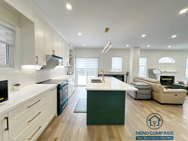 Open-concept interior renovation in Markham featuring a modern kitchen with white cabinetry, quartz countertops, a contrasting green island, and seamless connection to the living area. The layout improves circulation, natural light, and everyday functionality.