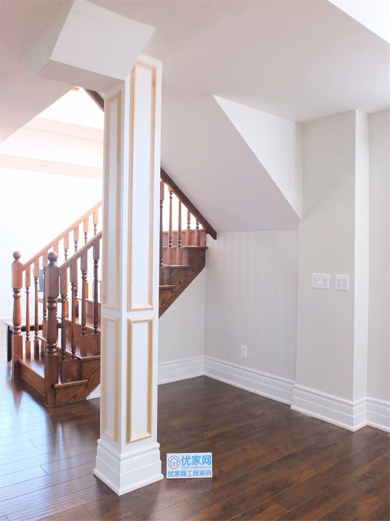 This Richmond Hill basement renovation features a spacious open-concept layout with dark hardwood flooring, modern pot lights, and structural columns with decorative trim. The upgraded staircase design adds warmth and elegance, making the basement ideal for a family living area or entertainment space.