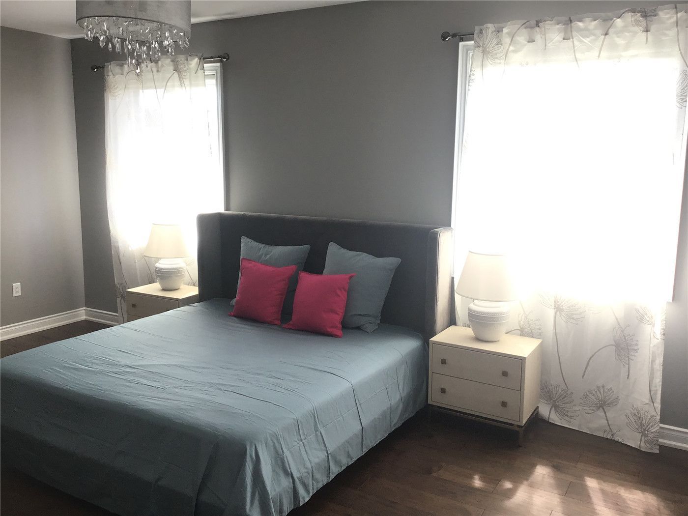 This Markham full home renovation features a cozy and modern bedroom with rich hardwood flooring, large windows, and soft neutral tones. The space is enhanced by natural light, elegant lighting fixtures, and a clean layout that creates a comfortable and relaxing atmosphere. Completed by a trusted Toronto Renovation Company, this bedroom design reflects both simplicity and everyday livability.