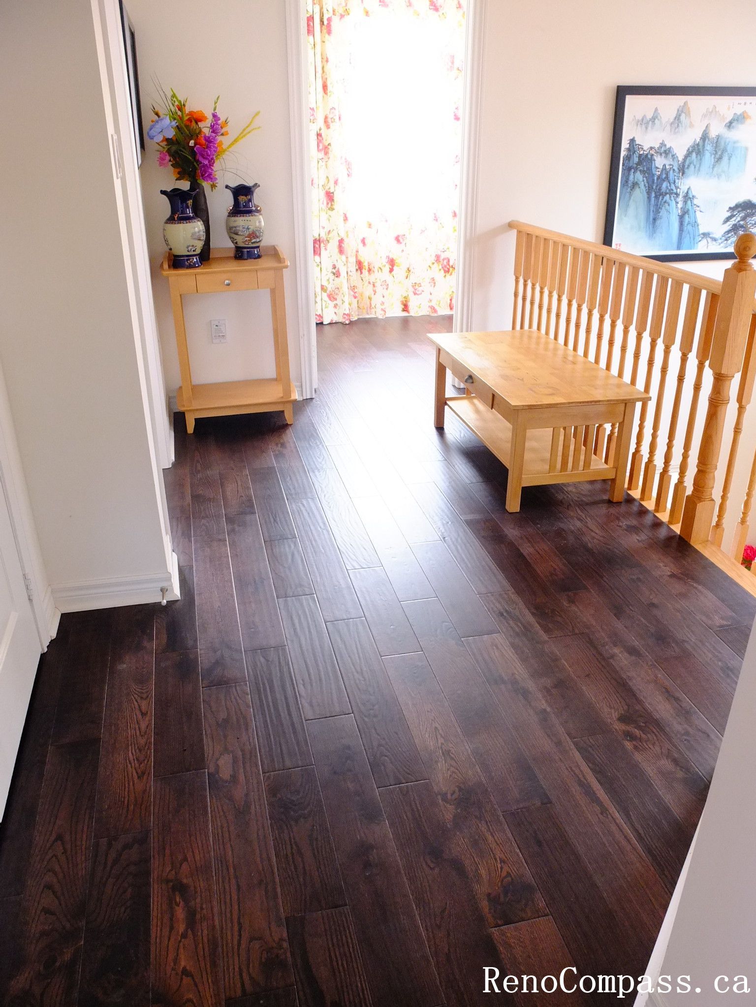 Toronto home hardwood flooring installation featuring deep-toned wood floors throughout the hallway and upper level. This professional flooring renovation enhances brightness, durability, and visual continuity, completed by Reno Compass for a clean and modern interior upgrade.