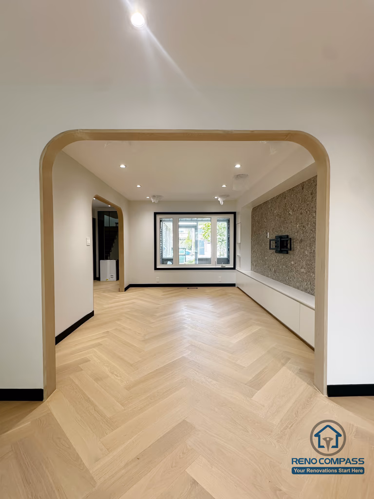 A beautifully designed open-concept living area featuring a soft-curve archway, light herringbone flooring, and a minimalist TV feature wall.
The warm tones and seamless flow between rooms create an inviting, modern, and airy atmosphere throughout the home. 一个以柔和弧形拱门为亮点的开放式客厅空间，搭配浅色人字拼地板与极简电视背景墙。
整体色调温暖、动线连贯，营造出现代、通透又舒适的居家氛围。