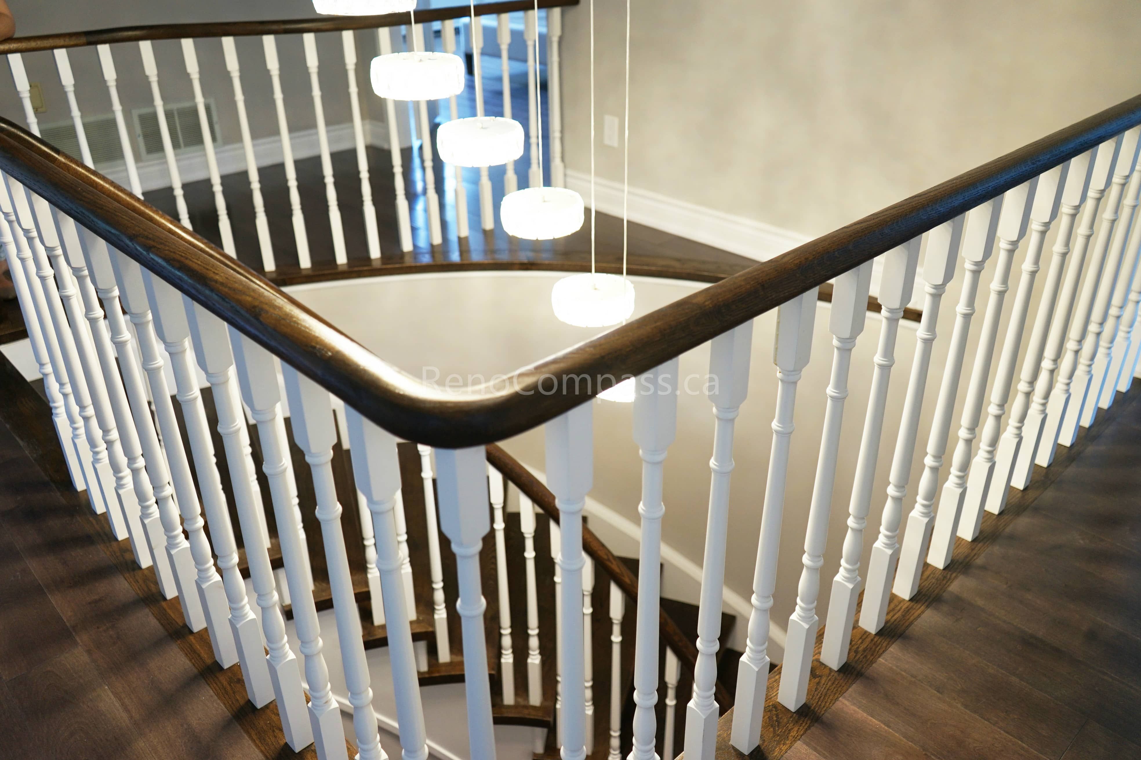 This North York interior renovation showcases an upgraded stair railing with classic white balusters, a dark wood handrail, and modern pendant lighting over the stairwell. The refined railing craftsmanship and layered lighting design enhance both safety and visual elegance within the home. Completed by a professional Toronto renovation company, this project highlights quality stair renovation work and thoughtful interior detailing for Toronto residences.
