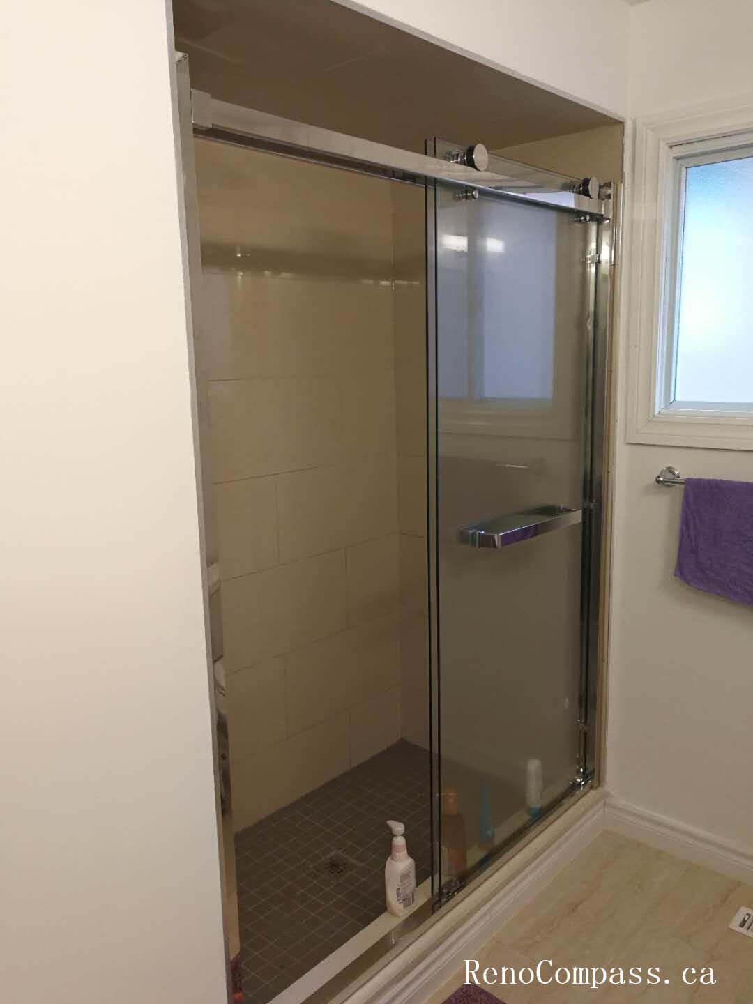 Basement bathroom renovation in Richmond Hill featuring a modern frameless glass shower enclosure with sliding door system and upgraded tile flooring. This renovation enhances functionality, maximizes space efficiency, and delivers a clean contemporary look with durable waterproof materials and professional installation.