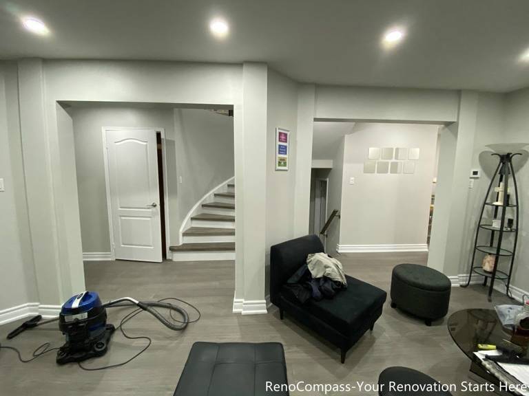 This Mississauga interior renovation features a modern open-concept living space with upgraded flooring, smooth ceilings, and recessed pot lights that create a bright and welcoming atmosphere. The redesigned layout highlights a custom staircase feature wall, contemporary trim work, and a seamless transition between living and dining areas. Completed by a professional Toronto renovation company, this renovation focuses on enhancing space flow, lighting quality, and overall home comfort while adding long-term value and a clean modern aesthetic.