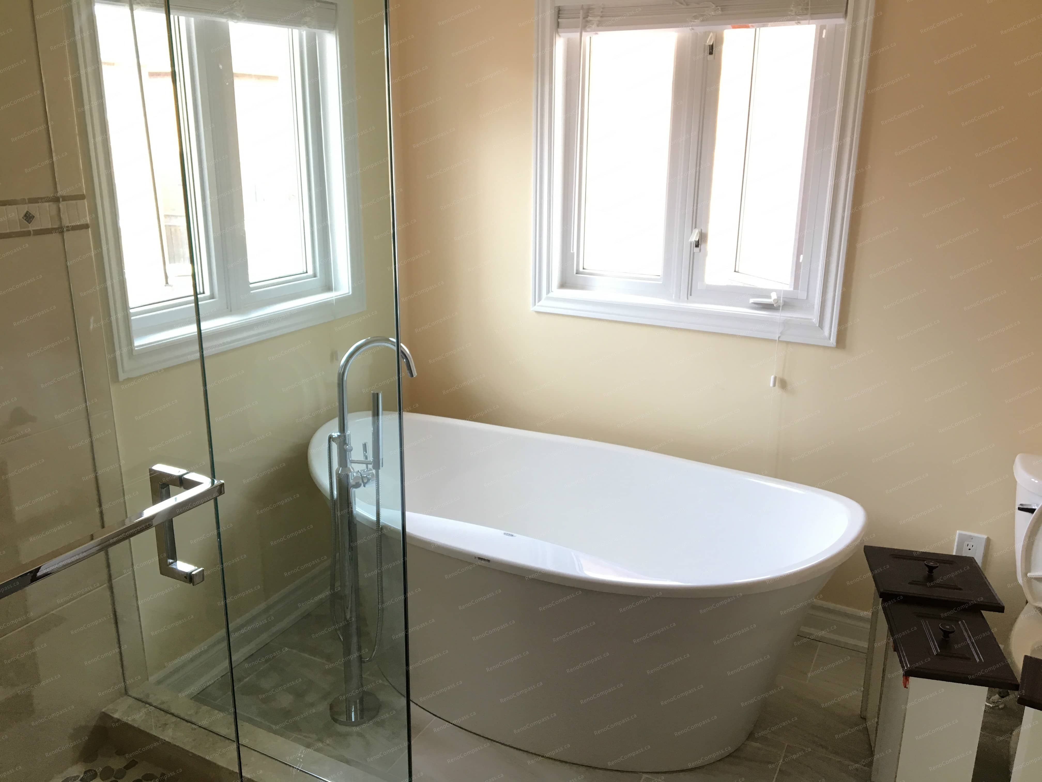 This Markham interior renovation showcases a luxury bathroom upgrade featuring a freestanding soaking tub, frameless glass shower, and modern fixtures. Large windows bring in natural light, enhancing the warm neutral palette and creating a relaxing spa-like atmosphere. Completed by a professional Toronto renovation company, this bathroom renovation combines comfort, elegance, and high-quality craftsmanship for everyday living.