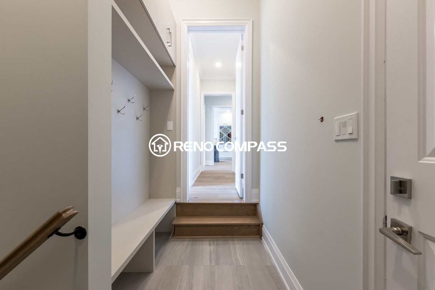 Custom mudroom and walk-in closet renovation in Newmarket featuring built-in bench seating, wall hooks and storage shelving. Designed and completed by a professional Toronto renovation company, this functional entry space helps keep the home organized while adding a clean modern look.