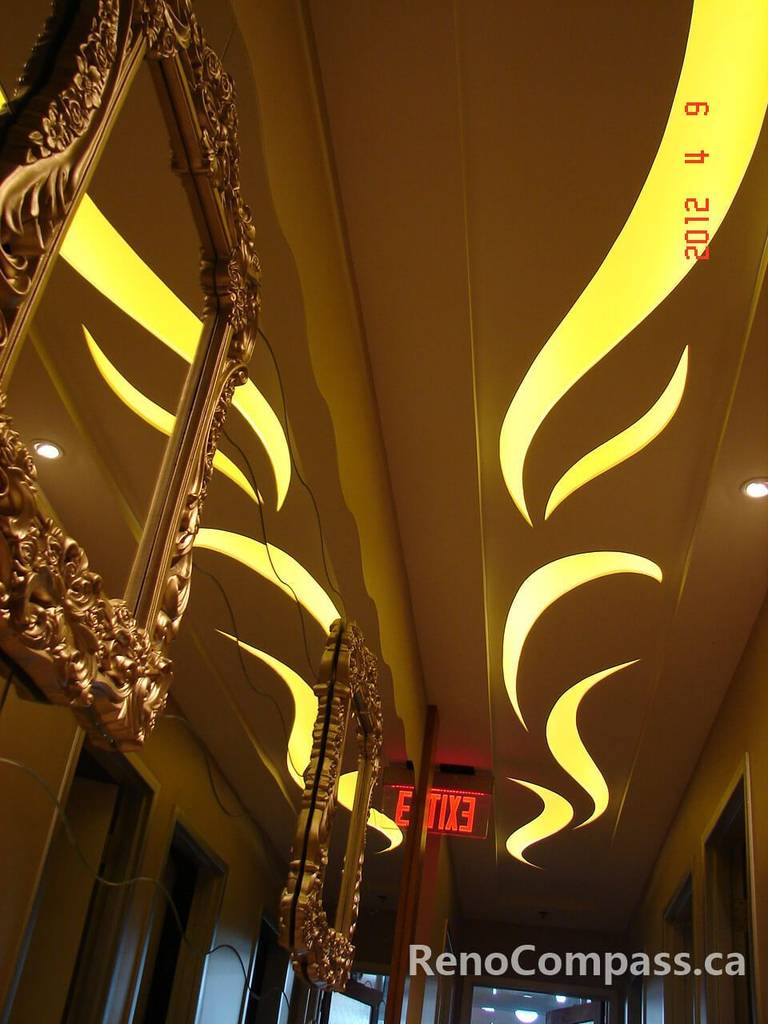 This Toronto beauty salon renovation highlights a stunning custom LED ceiling feature that creates a flowing, artistic lighting effect throughout the hallway. Paired with ornate gold mirrors and warm ambient tones, the design enhances the salon’s luxury atmosphere and elevates the client experience. Completed by a professional Toronto renovation company, this commercial interior showcases creative lighting design, refined detailing, and high-end craftsmanship tailored for modern beauty and spa spaces.