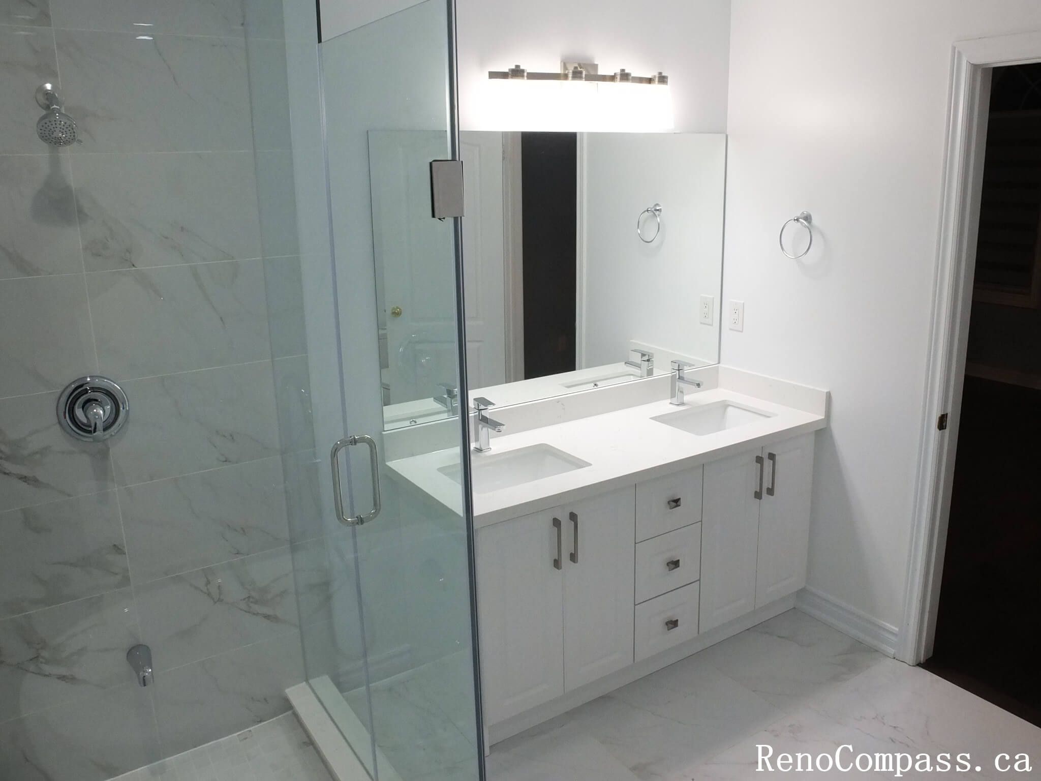 This Richmond Hill bathroom renovation showcases a contemporary double-sink vanity, frameless glass shower, and marble-look tile finishes. Completed by an experienced Toronto renovation company, the design focuses on clean lines, practical storage, and a bright, spacious layout. The combination of modern fixtures, neutral tones, and elegant materials creates a refined and functional bathroom ideal for everyday comfort and long-term durability.