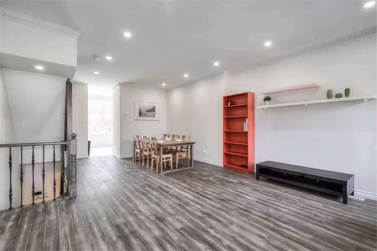 This Thornhill interior renovation features a spacious open-concept living and dining area with newly installed wood-style flooring, modern recessed lighting, and fresh neutral wall finishes. The upgraded staircase railings and clean layout enhance both functionality and visual appeal, creating a bright and welcoming home environment. Completed by a professional Toronto renovation team, this project highlights quality craftsmanship and modern interior transformation for comfortable family living.