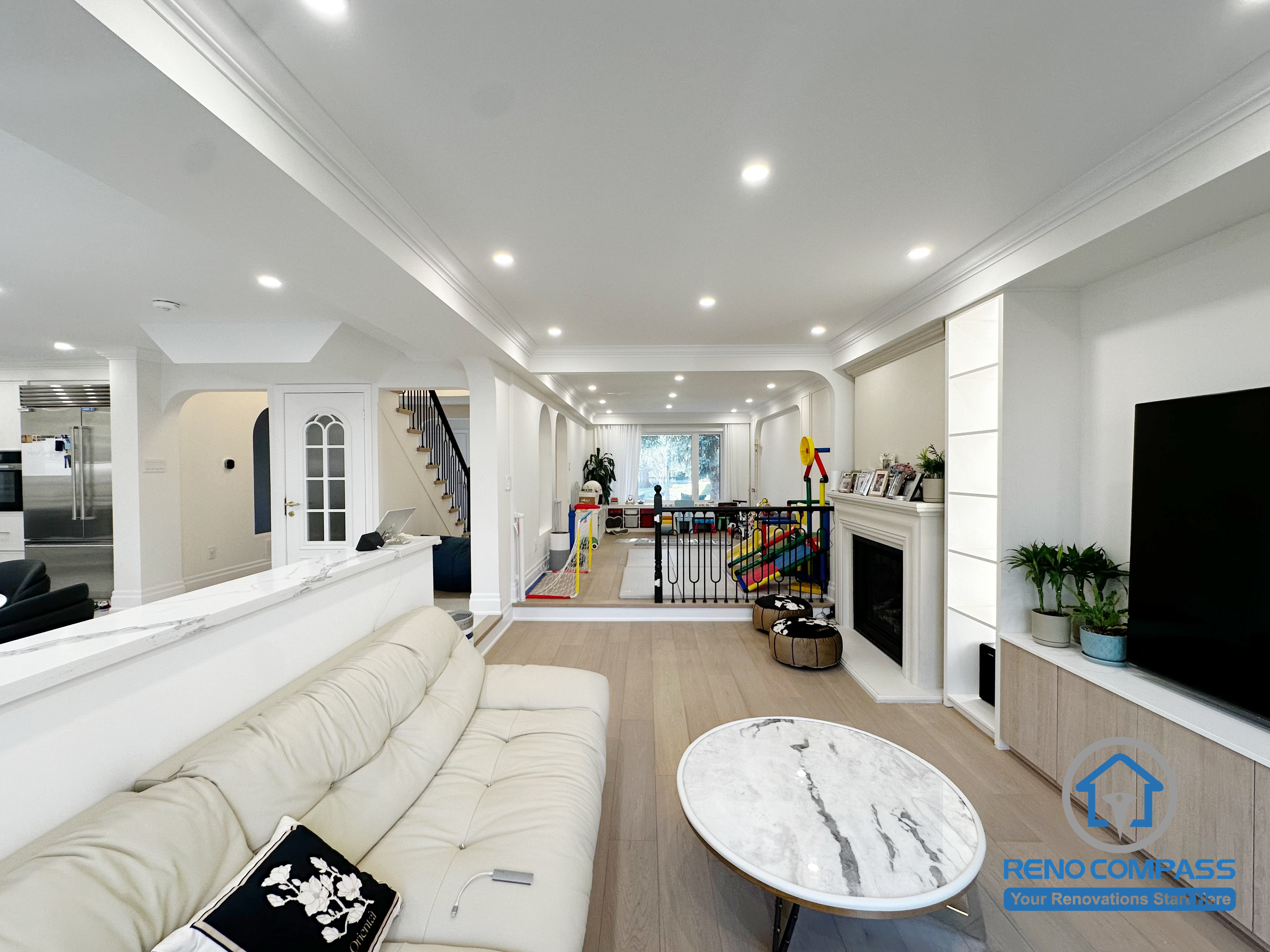 This Markham interior renovation reimagines the main living area as a bright, open-concept space that seamlessly connects lounging, dining, and family activity zones. The layout is designed to enhance visual continuity while maintaining comfortable separation between different functions of the home.

A half-height partition helps define the living room without blocking sightlines, allowing natural light to flow through the space. Recessed ceiling lighting and consistent architectural details create a clean, cohesive look throughout the interior. The open connection to the kitchen and family areas supports everyday interaction and makes the space ideal for both relaxation and entertaining.

By focusing on layout balance, lighting design, and long-term usability, this renovation delivers a refined yet practical interior environment suited for modern family living in Markham.