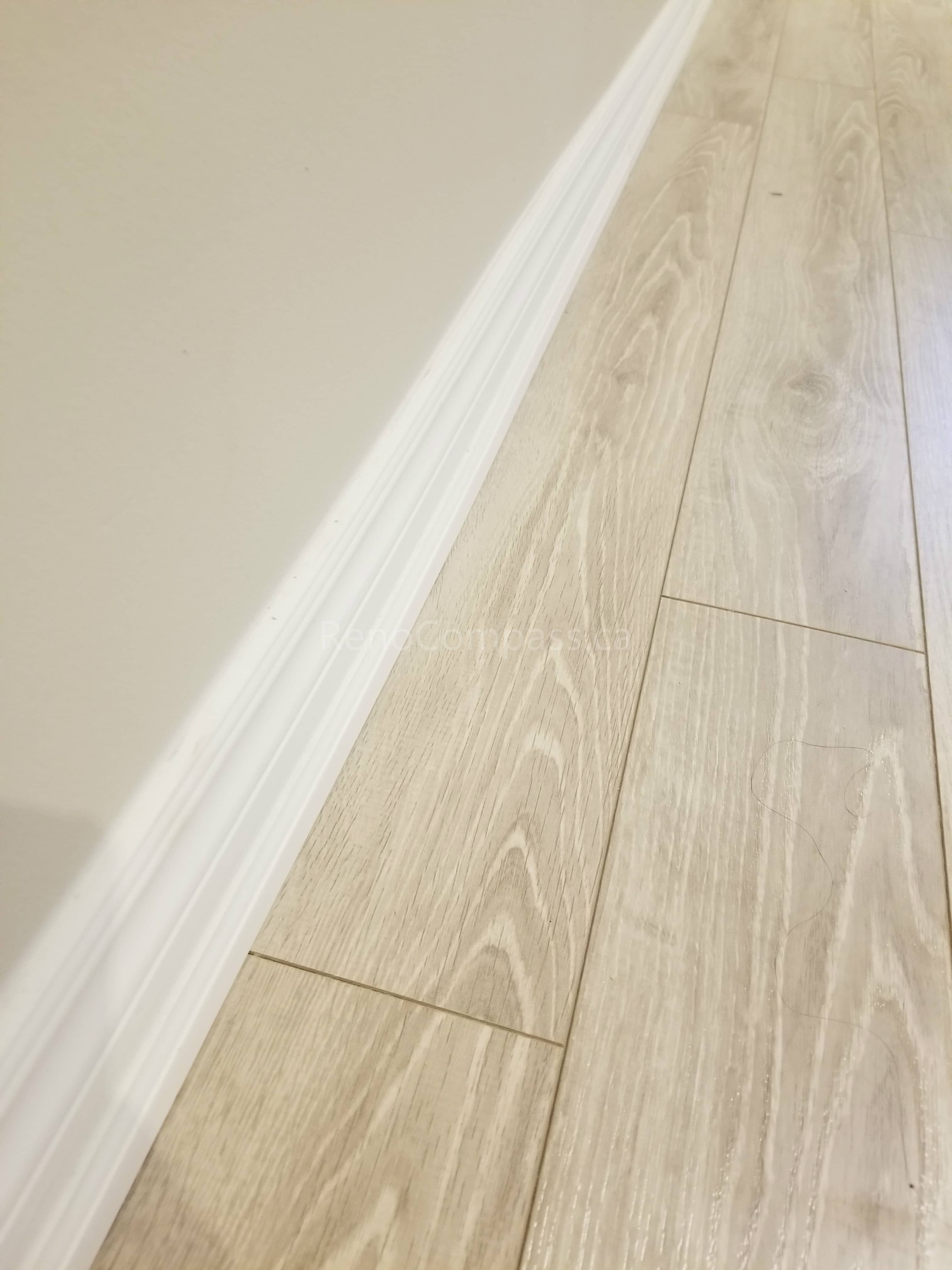 This Toronto basement renovation showcases newly installed light wood flooring paired with clean white baseboards for a modern and elegant finish. The durable laminate flooring enhances brightness and creates a warm, contemporary look while providing easy maintenance for basement living spaces. Installed by Reno Compass Inc., this flooring upgrade adds both style and functionality to the newly renovated basement interior.