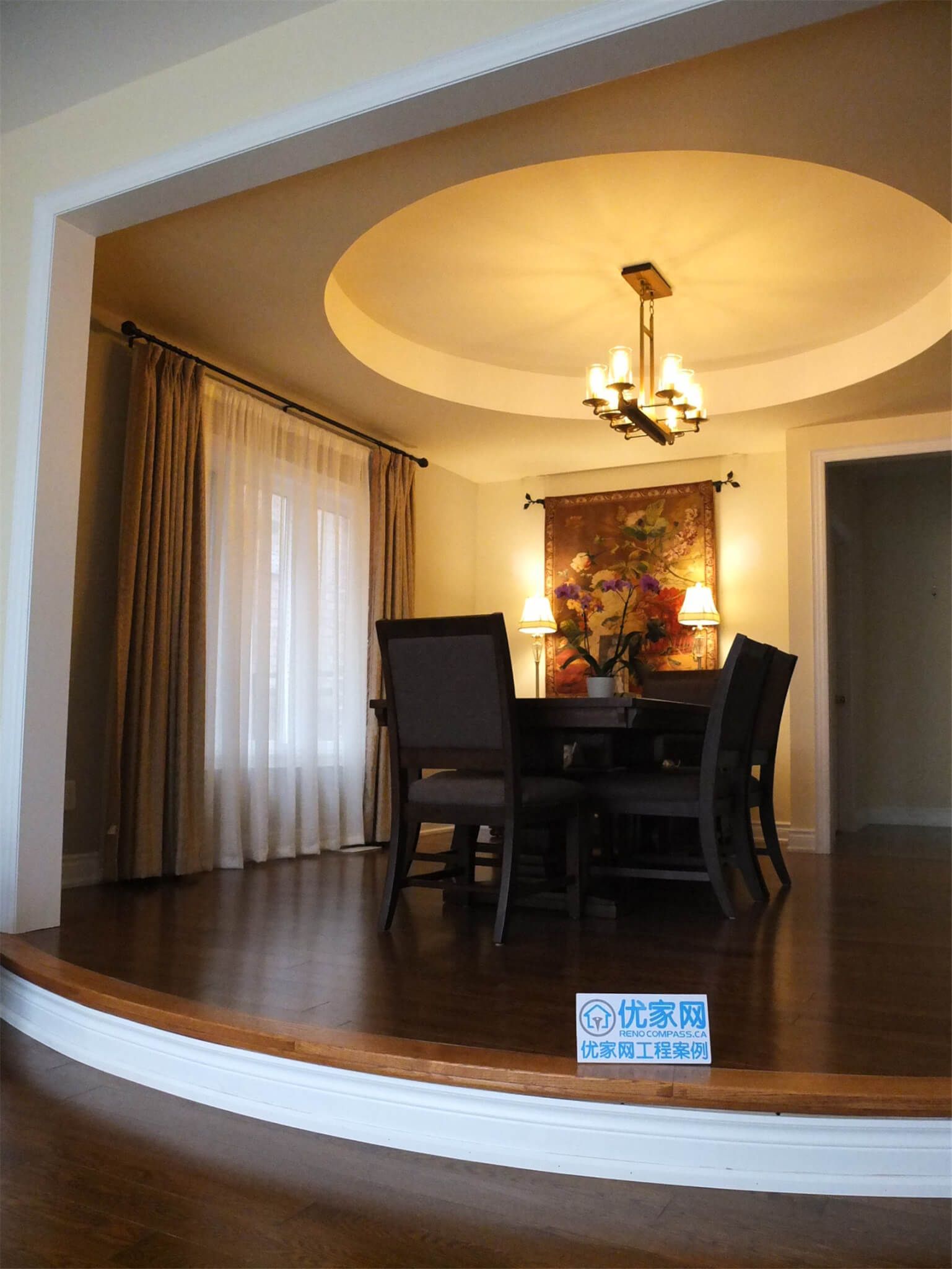 This Aurora flooring renovation highlights a beautifully upgraded dining room featuring rich hardwood flooring and elegant interior details. The polished wood floor complements the elevated dining area, curved step design, and warm ceiling lighting, creating a sophisticated and inviting atmosphere. Completed by a professional Toronto renovation company, the flooring installation enhances both the visual appeal and durability of this refined dining space.