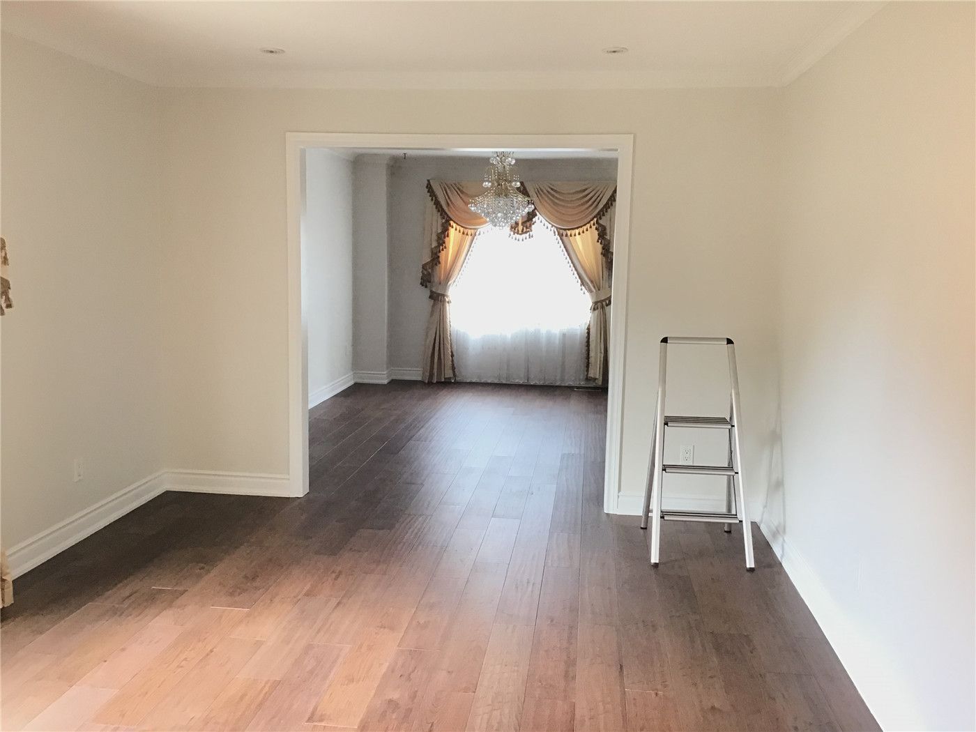 Stunning dark walnut hardwood flooring installation for a Markham residential project. This open-concept living area features professional floor leveling, seamless transitions, and updated white baseboards.