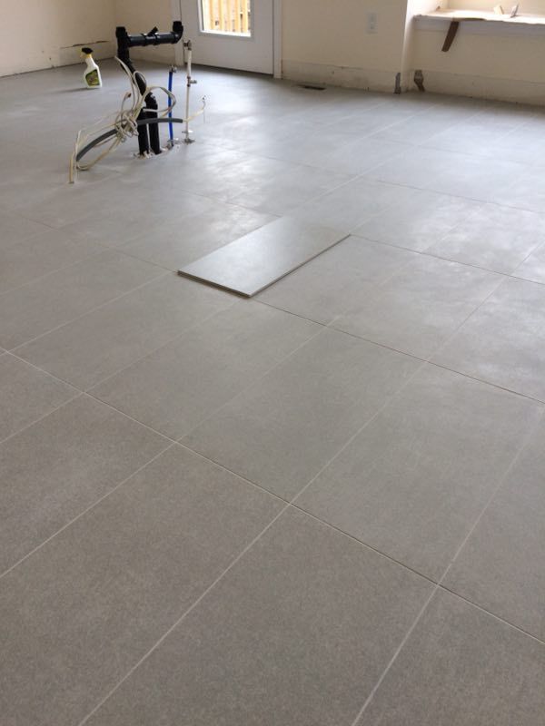 Large-format tile flooring installation in a Toronto interior renovation project. Clean tile alignment, consistent grout lines, and precise layout preparation help create a modern, durable, and easy-maintenance living space for everyday use.