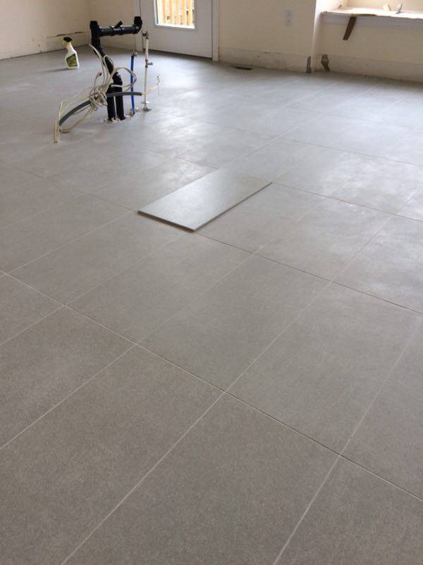Large-format tile flooring installation in a Toronto interior renovation project. Clean tile alignment, consistent grout lines, and precise layout preparation help create a modern, durable, and easy-maintenance living space for everyday use.