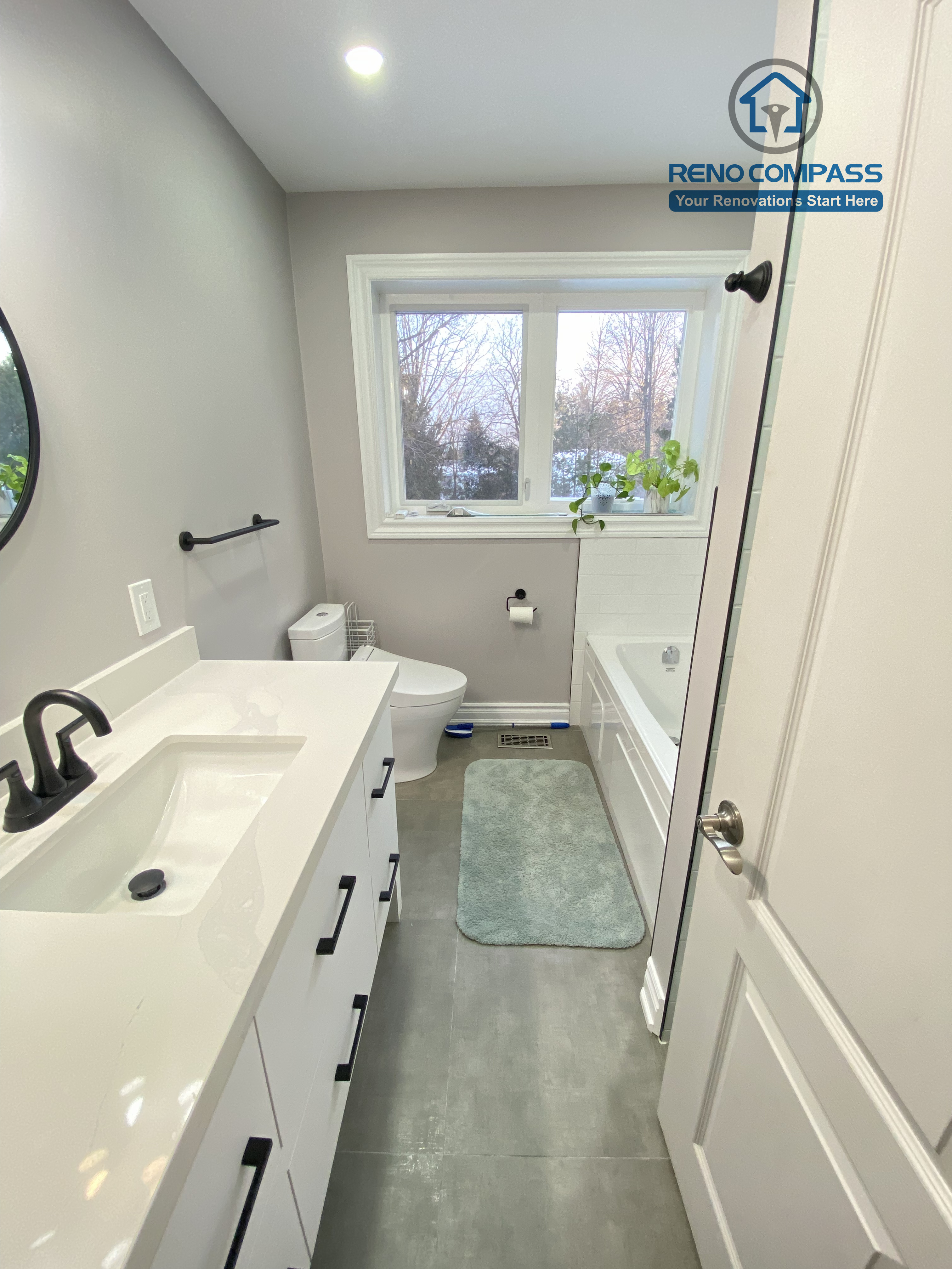 This North York bathroom renovation features a modern white vanity with a quartz countertop, matte black hardware, and a clean, functional layout. The neutral wall color, large-format floor tiles, and integrated lighting create a bright and timeless bathroom design, completed by a Toronto renovation company focused on quality craftsmanship and everyday usability