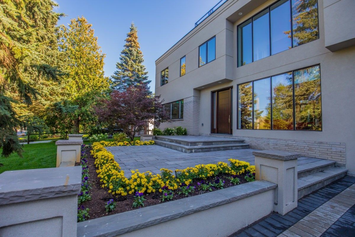 Front exterior view of a fully renovated 5000 sqft luxury home in Toronto, featuring modern architectural design, large windows, stone walkway, custom landscaping, and a spacious entrance. This high-end residential renovation project showcases premium outdoor detailing and contemporary home improvement completed by Reno Compass Inc., a trusted Toronto renovation company specializing in full-scale interior and exterior transformations.