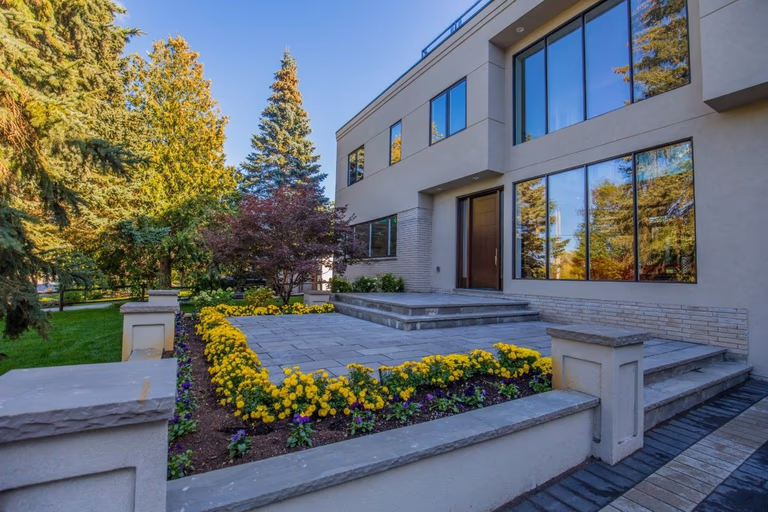 Front exterior view of a fully renovated 5000 sqft luxury home in Toronto, featuring modern architectural design, large windows, stone walkway, custom landscaping, and a spacious entrance. This high-end residential renovation project showcases premium outdoor detailing and contemporary home improvement completed by Reno Compass Inc., a trusted Toronto renovation company specializing in full-scale interior and exterior transformations.