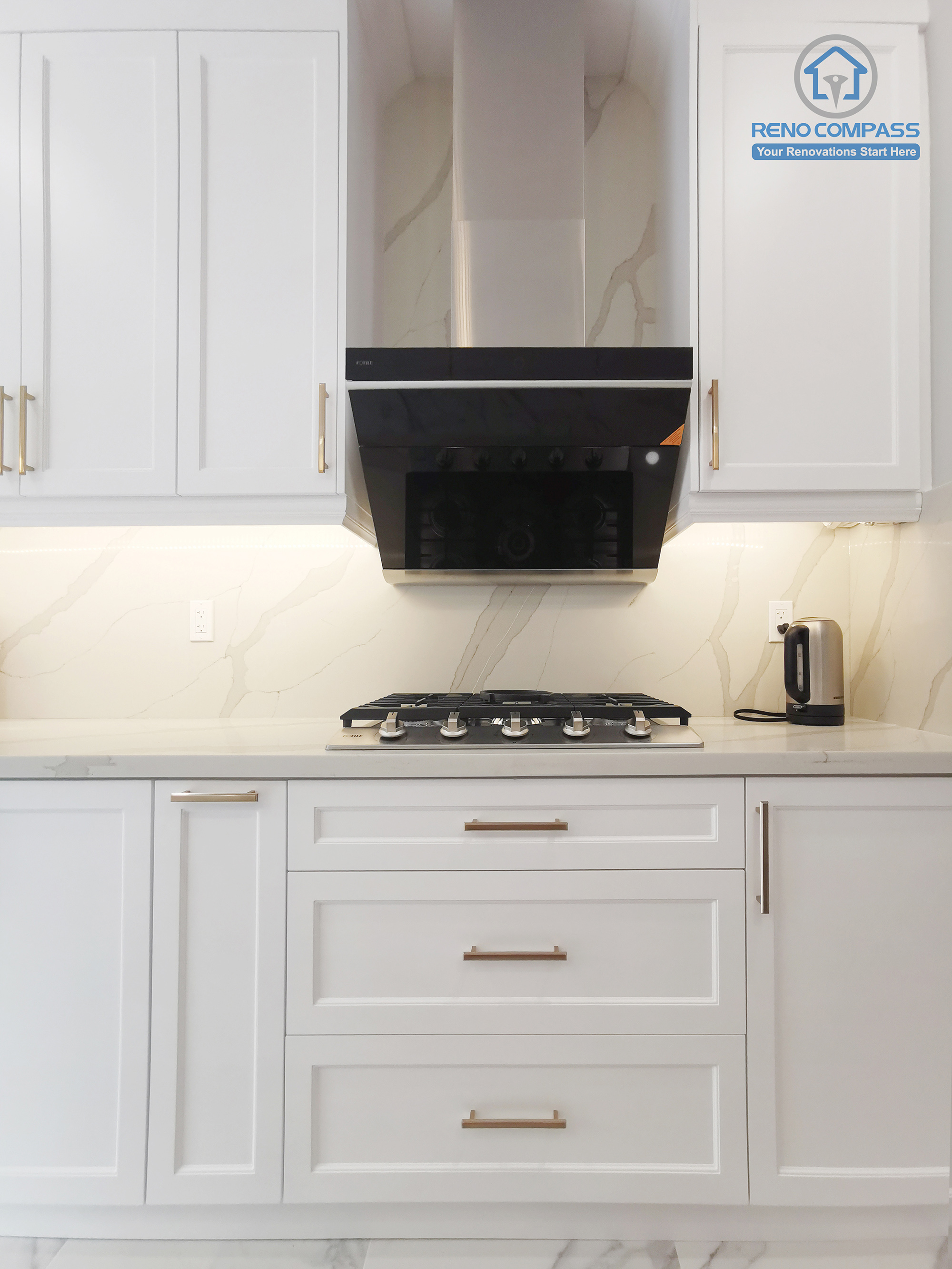 This Markham interior renovation highlights a well-organized kitchen cooking zone designed for efficiency, safety, and visual balance. The layout features a built-in gas cooktop paired with a sleek, modern range hood that provides effective ventilation while maintaining a clean elevation. White shaker cabinetry with warm metal hardware frames the space symmetrically, offering ample storage and a refined, timeless appearance. The full-height stone-look backsplash enhances durability and visual continuity across the work surface. Completed by Reno Compass, this kitchen renovation demonstrates a thoughtful approach to functional zoning, proportion control, and long-term usability for modern Markham homes.
