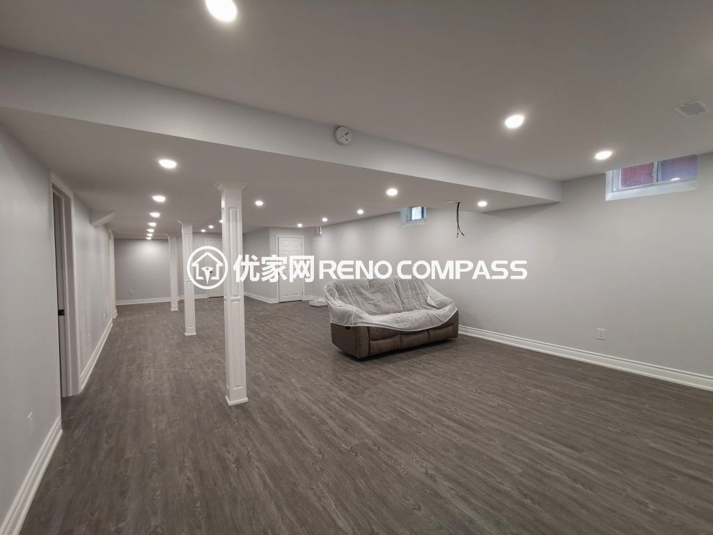 Richmond Hill basement renovation featuring a spacious open-concept layout, modern waterproof flooring, structural support columns, and recessed pot light installation. The newly finished basement offers bright lighting and flexible living space, completed by a professional Toronto renovation company.