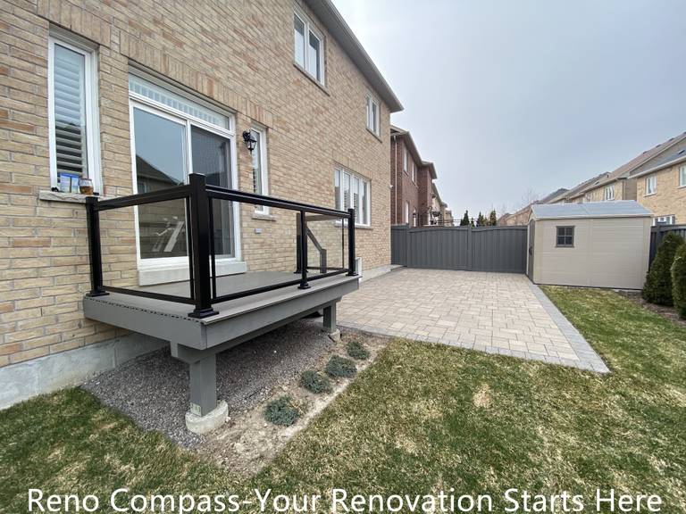 Composite backyard deck renovation in Newmarket featuring durable deck boards and black aluminum railing with clean, modern lines. The raised deck structure provides a safe and functional outdoor platform while enhancing the connection between indoor living space and the backyard. Built by a professional Toronto renovation company with a focus on structural stability and long-term performance.