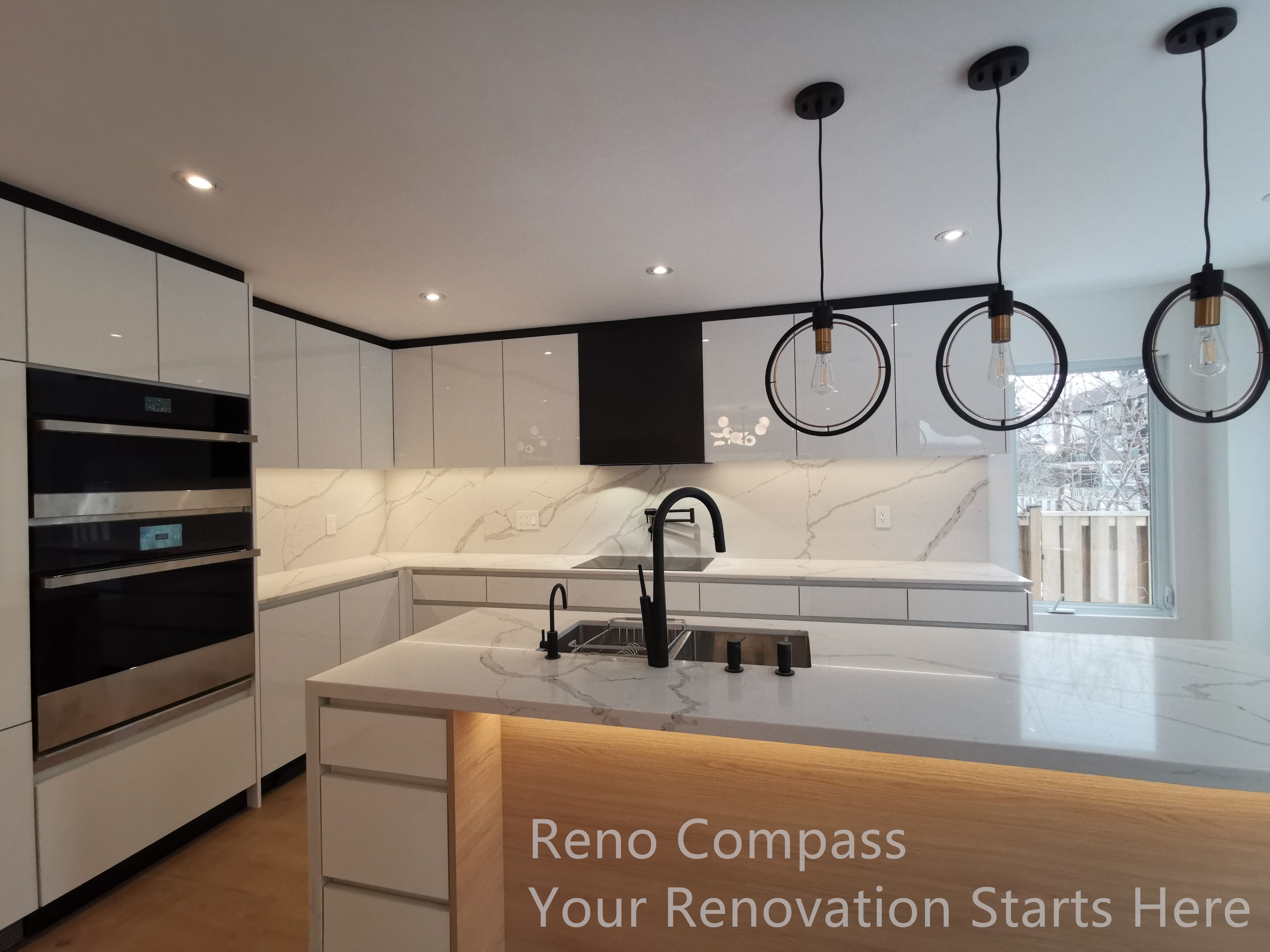This image showcases a modern kitchen completed as part of a Markham interior renovation. The design features sleek white cabinetry paired with a full-height marble-look backsplash, creating a clean and cohesive visual flow. A waterfall island with integrated warm lighting serves as both a functional workspace and a central gathering point. Matte black fixtures and built-in appliances add contrast while maintaining a refined, contemporary aesthetic. The layout emphasizes efficient workflow, generous storage, and long-term practicality, reflecting a kitchen designed for everyday use as well as entertaining.