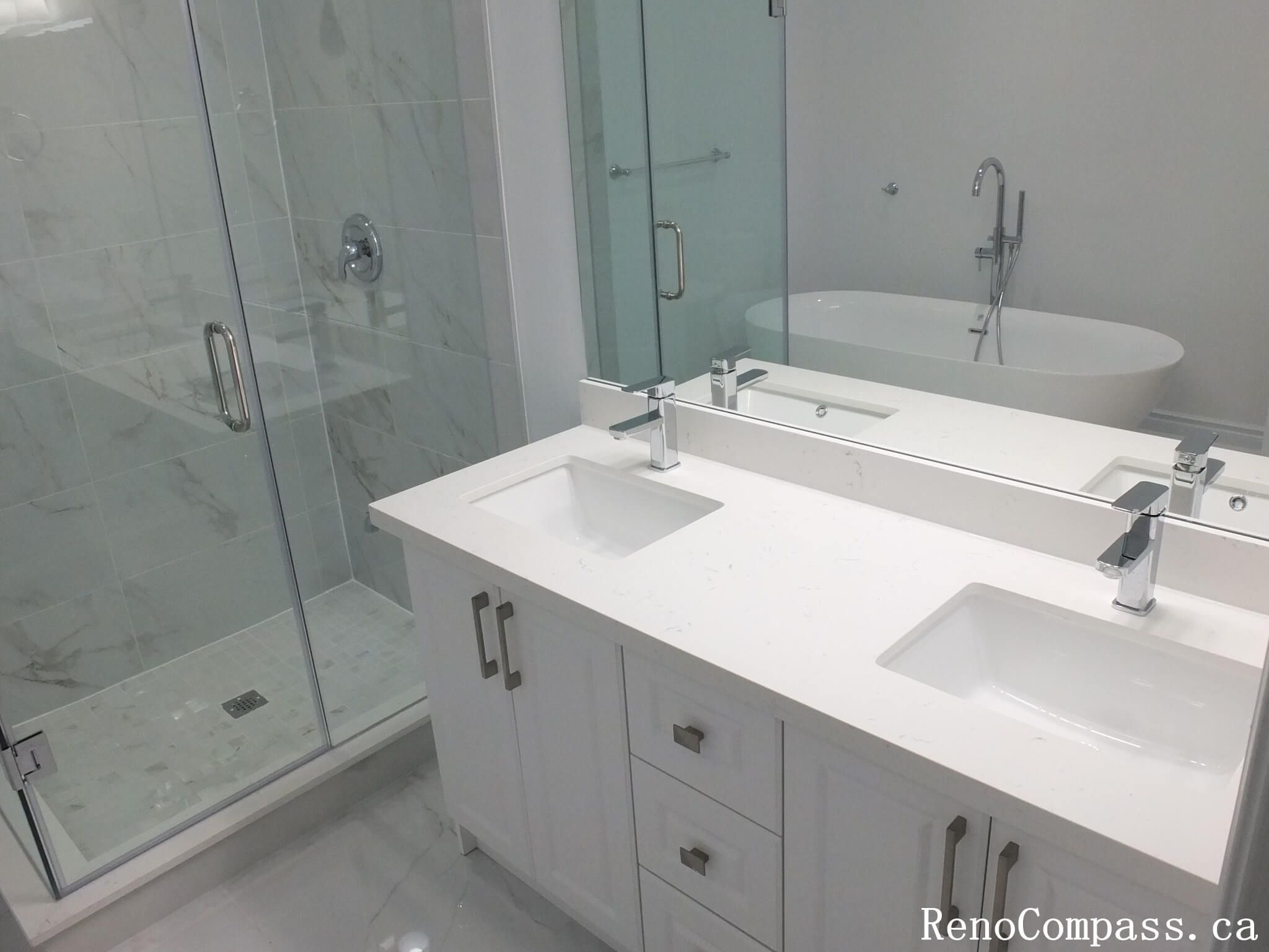 This Richmond Hill bathroom renovation showcases a contemporary double-sink vanity, frameless glass shower, and marble-look tile finishes. Completed by an experienced Toronto renovation company, the design focuses on clean lines, practical storage, and a bright, spacious layout. The combination of modern fixtures, neutral tones, and elegant materials creates a refined and functional bathroom ideal for everyday comfort and long-term durability.