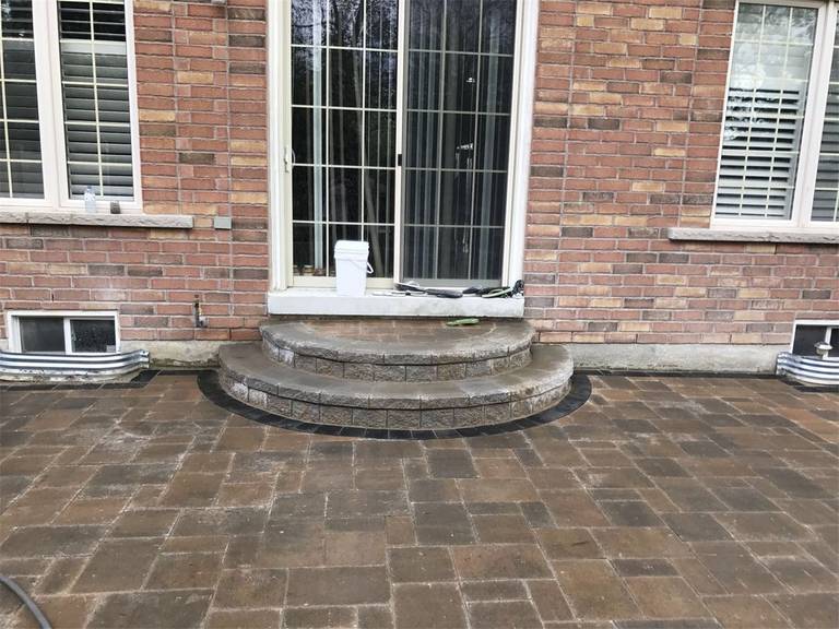 This Markham landscaping renovation features a newly installed interlocking stone patio complemented by elegant curved stone steps leading to the backyard entrance. The carefully designed layout enhances accessibility while creating a clean and welcoming outdoor space. Completed by a professional Toronto Renovation Company, the project combines durable materials with refined landscaping details to improve both functionality and visual appeal.