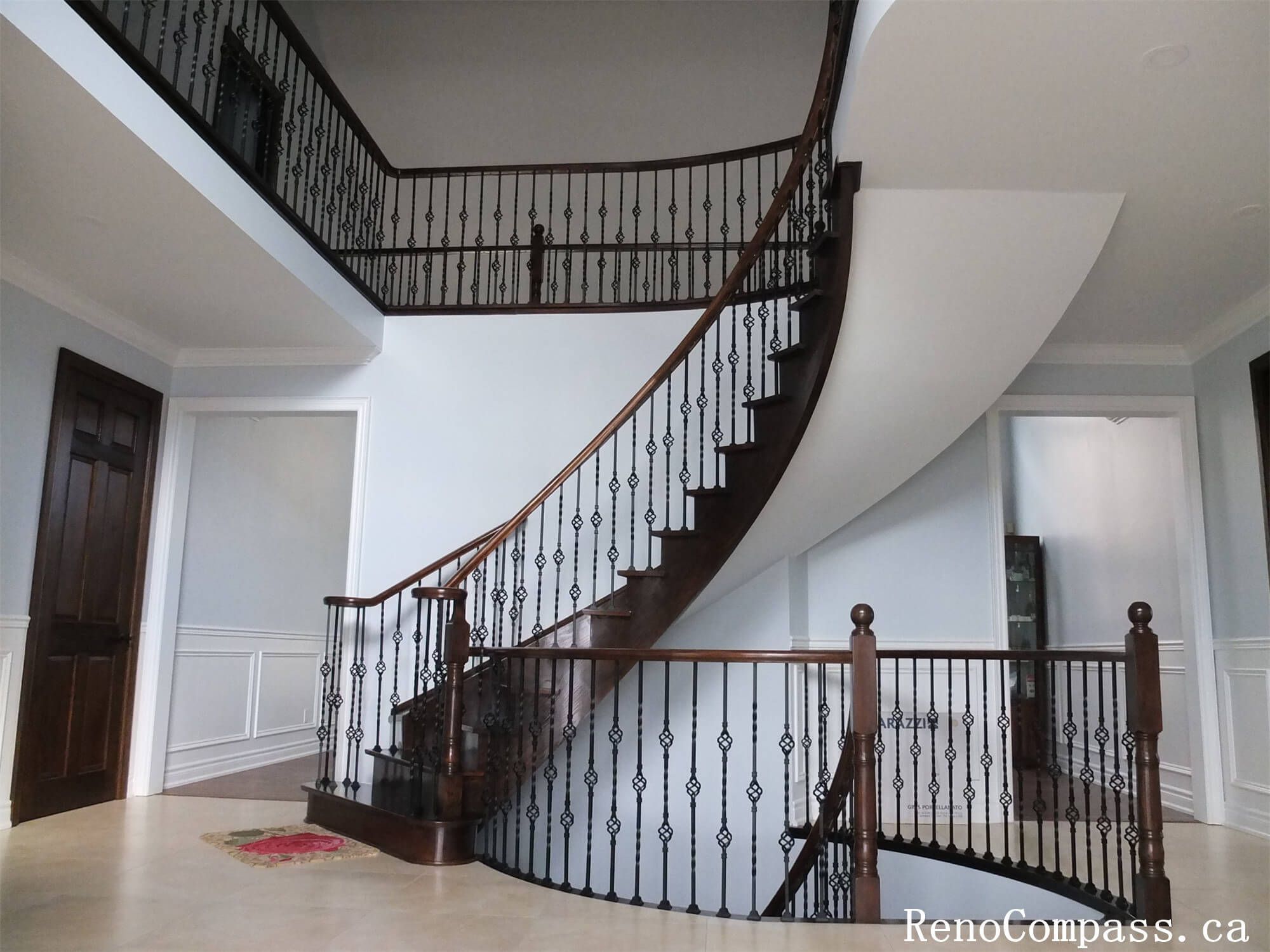 This Richmond Hill interior renovation features a stunning custom curved staircase and grand foyer designed to enhance the home’s architectural elegance. The project includes dark wood stair treads, decorative iron railings, upgraded wall paneling, and modern lighting to create a refined entrance space. The open foyer layout improves visual flow between levels while adding luxury and value to the property. Completed by a trusted Toronto renovation company, this staircase and interior upgrade showcases quality craftsmanship and timeless design for upscale residential living.