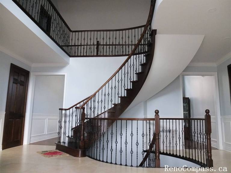 This Richmond Hill interior renovation features a stunning custom curved staircase and grand foyer designed to enhance the home’s architectural elegance. The project includes dark wood stair treads, decorative iron railings, upgraded wall paneling, and modern lighting to create a refined entrance space. The open foyer layout improves visual flow between levels while adding luxury and value to the property. Completed by a trusted Toronto renovation company, this staircase and interior upgrade showcases quality craftsmanship and timeless design for upscale residential living.