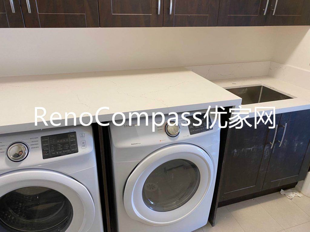 Modern Richmond Hill basement laundry room renovation featuring front-load washer and dryer, custom cabinetry, quartz countertop, and utility sink. Completed by Reno Compass Inc., this functional laundry space upgrade improves storage, efficiency, and everyday convenience.