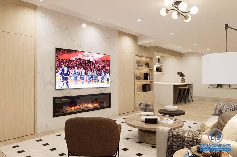 Modern basement renovation in Newmarket featuring a custom TV wall with fireplace and built-in cabinetry. Clean, warm design ideal for family living space.